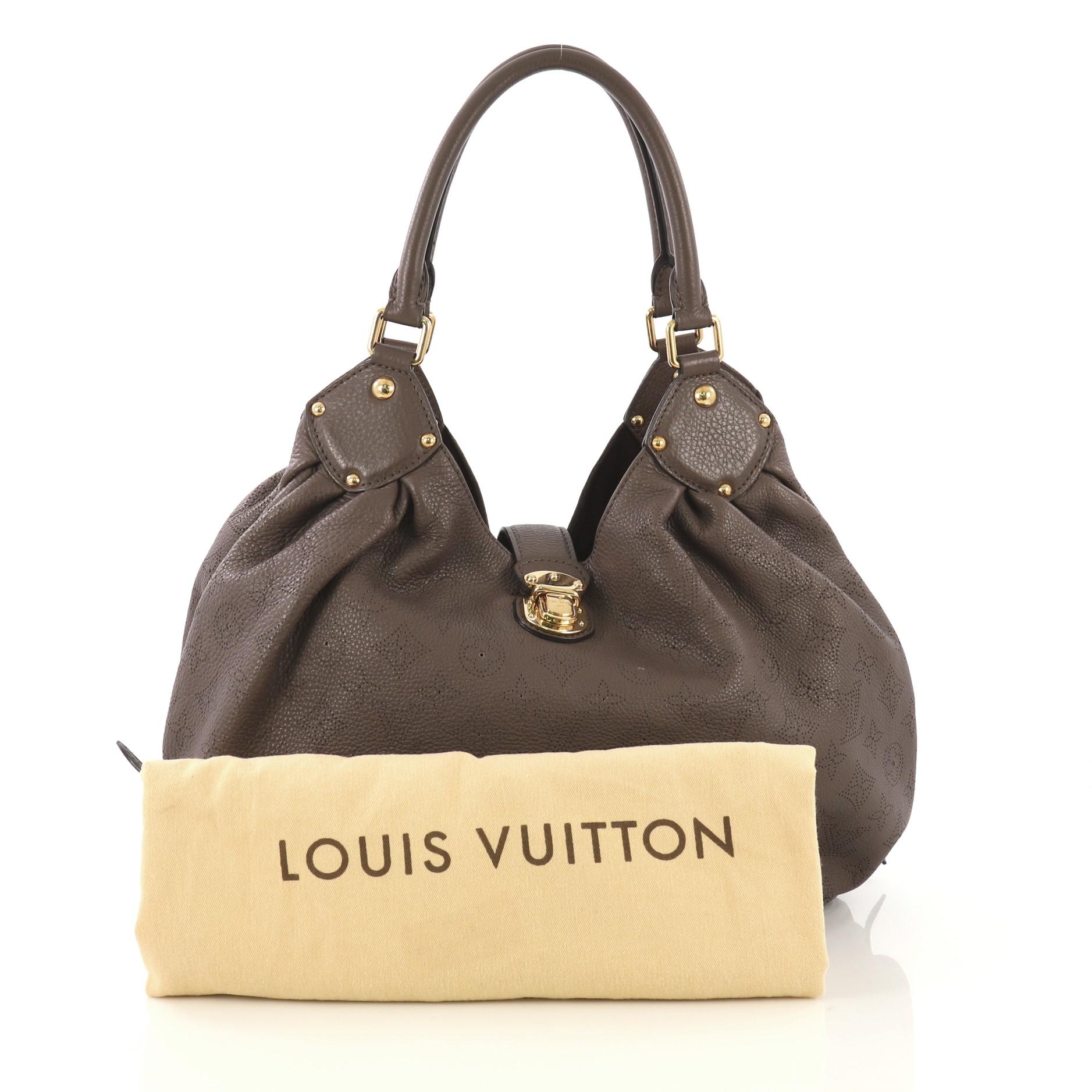 This Louis Vuitton L Hobo Mahina Leather, crafted from brown monogram mahina leather, features dual rolled handles, buckle and stud details, and gold-tone hardware. Its engraved top flap push-lock closure opens to a brown microfiber interior with