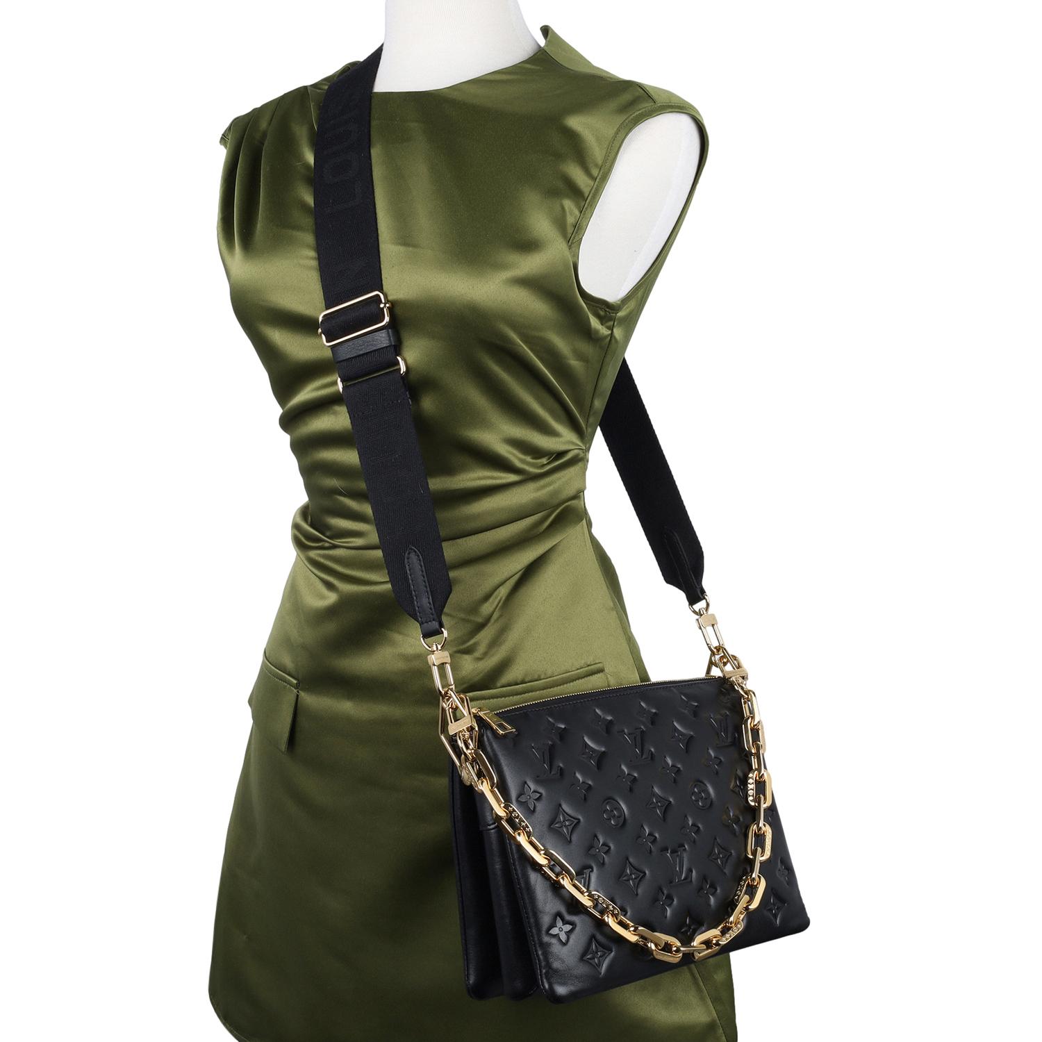 Authentic Louis Vuitton Lambskin Embossed Monogram Coussin PM in Black. Features soft puffy lambskin in black and embossed with the Louis Vuitton monogram, gold hardware, zipper top closure, pink interior with middle zipper pocket, gold edge chain