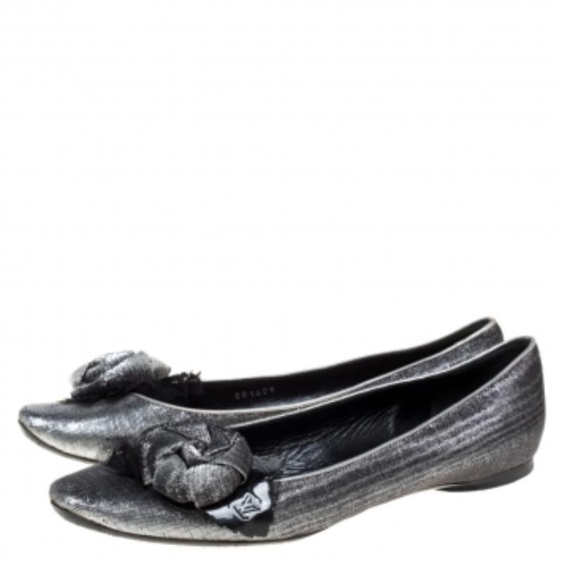 Raise the style bar wherever you go with this pair of Louis Vuitton ballet flats. Made of lamé fabric in a silver hue with black patent leather trim, they carry rose appliques on the pointed toes and comfortable insoles. They are finished with