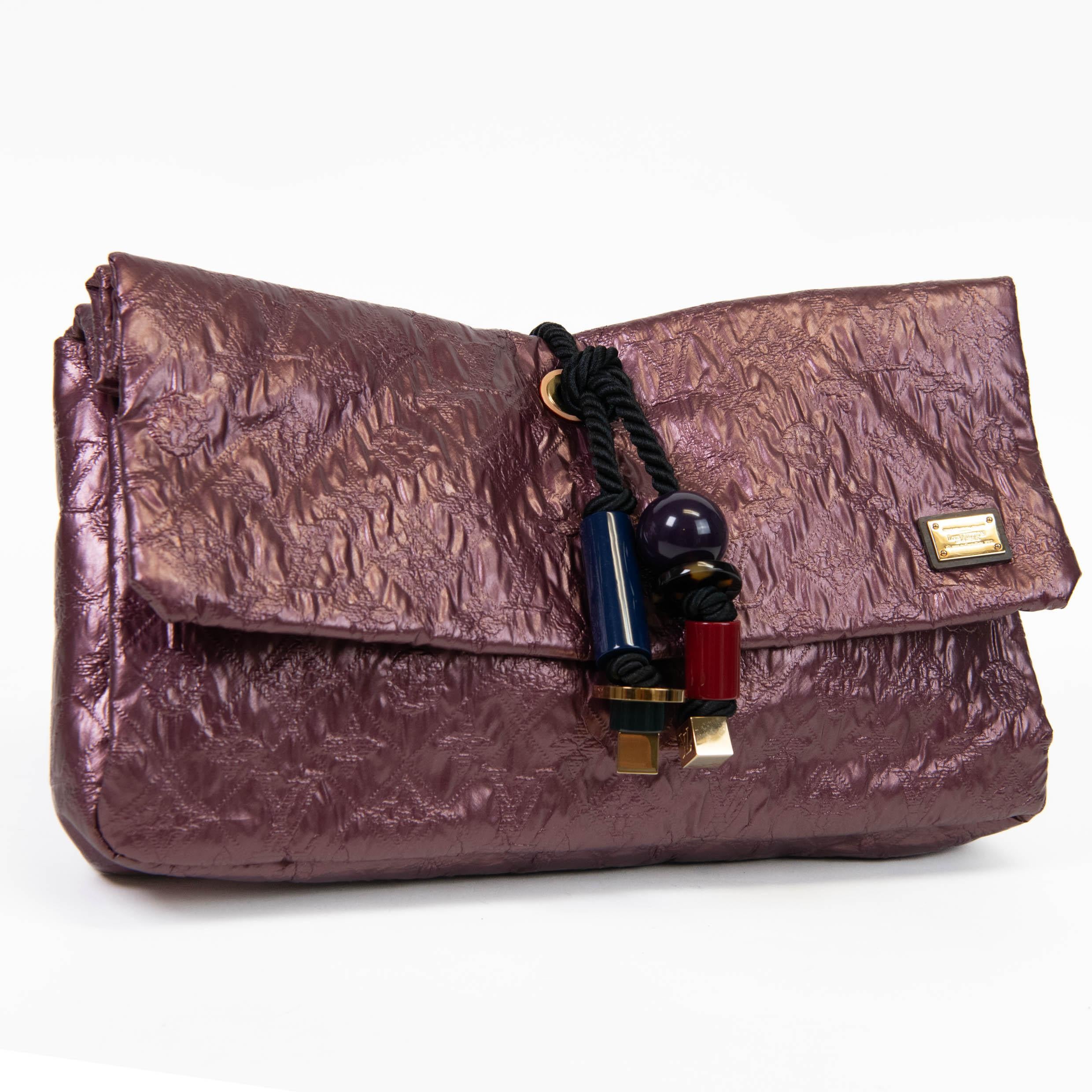 100% authentisch

Diese atemberaubende Clutch zum Umklappen ist aus metallischem Monogram-Textil mit reicher Tiefe und Schimmer und einer mit Acrylperlen besetzten Seilquaste gefertigt. Die Klappe öffnet sich zu einem Innenraum aus Stoff mit einer
