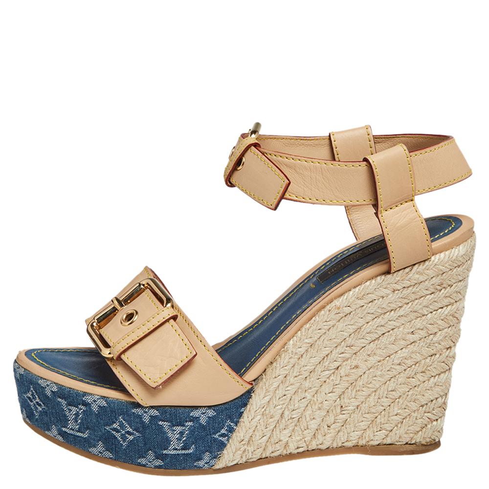 These chic sandals by Louis Vuitton will pair well with everything. These casual wedges are made from beige leather and monogram printed denim. They feature open toes, buckled ankle straps, and espadrille style 11 cm wedges. The padded blue leather
