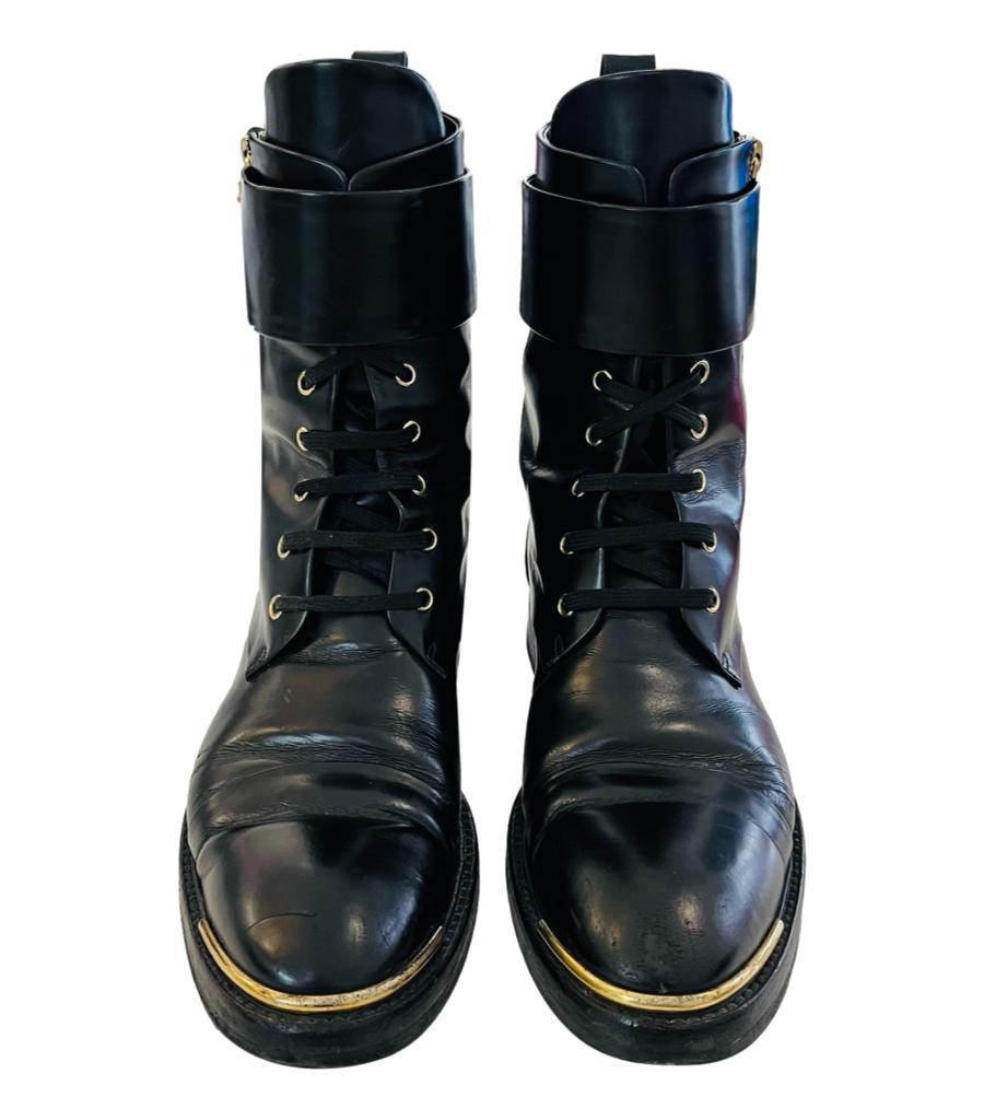 Louis Vuitton Leather Diplomacy Ranger Combat Boots
Black boots crafted in shiny calfskin leather and designed with wide strap closure with two buckles.
Detailed with gold plaque to the round toe and lace-up front with side zipper