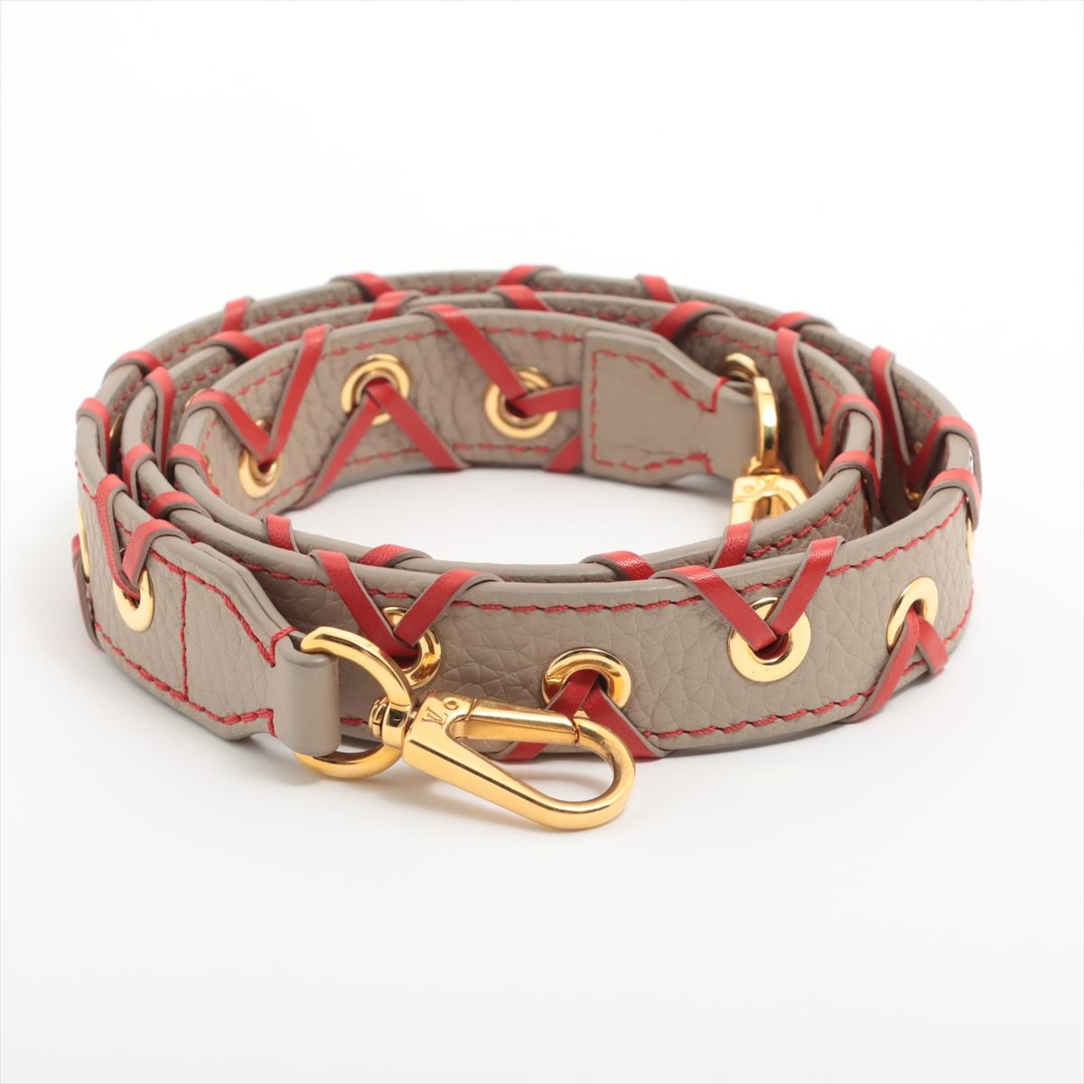 The Louis Vuitton Leather Shoulder Strap in Taupe and Red is an elegant accessory designed to personalize and enhance your Louis Vuitton handbag. Crafted from premium leather, the strap features a sophisticated taupe exterior complemented by a