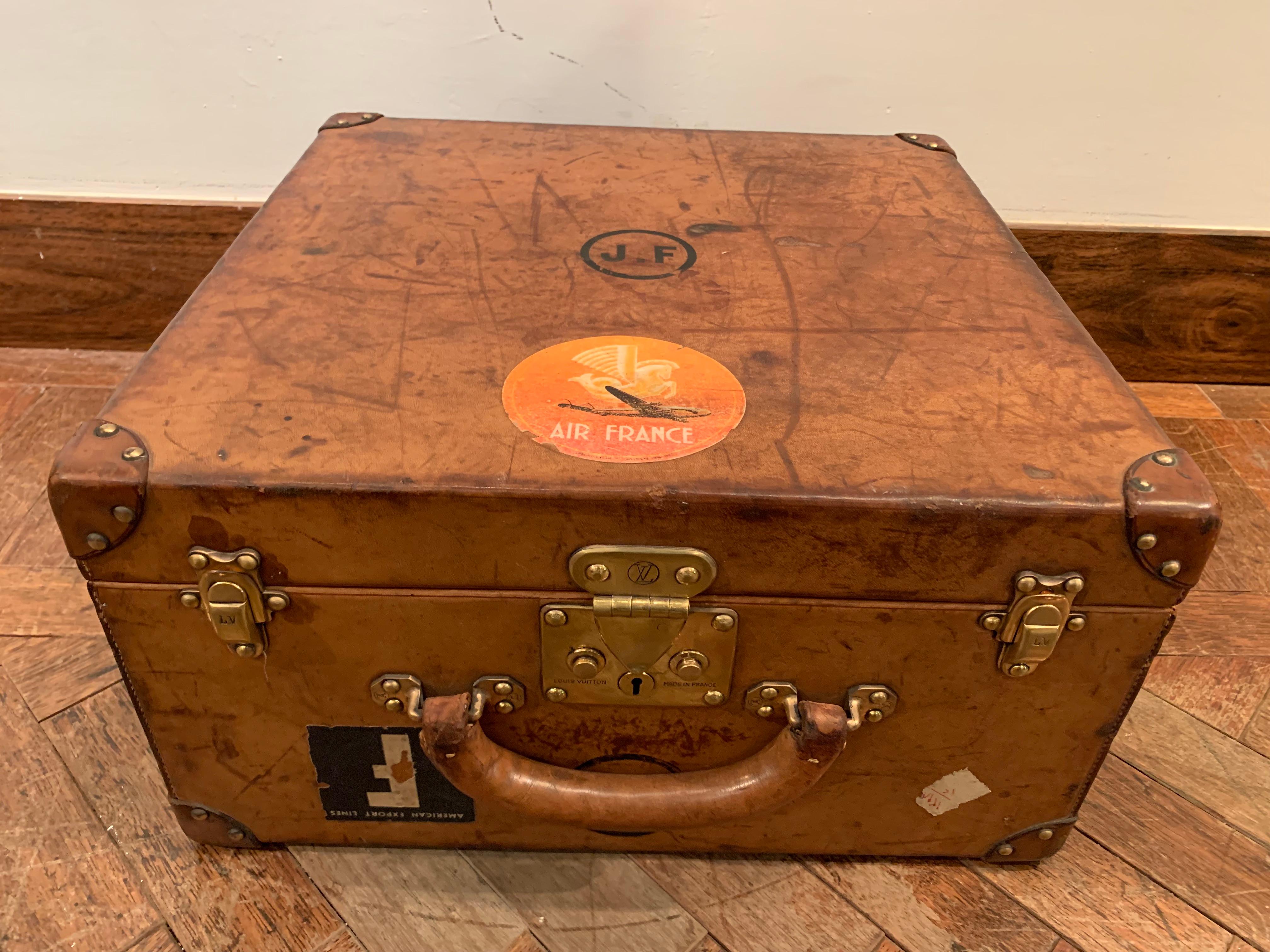 This beautiful Louis Vuitton leather suitcase features a light brown leather with marks of use and time, the initials OJ.F or J.FO are painted on the top of the suitcase.
Corners are made of leather and nailed to the suitcase by brass nails.

The