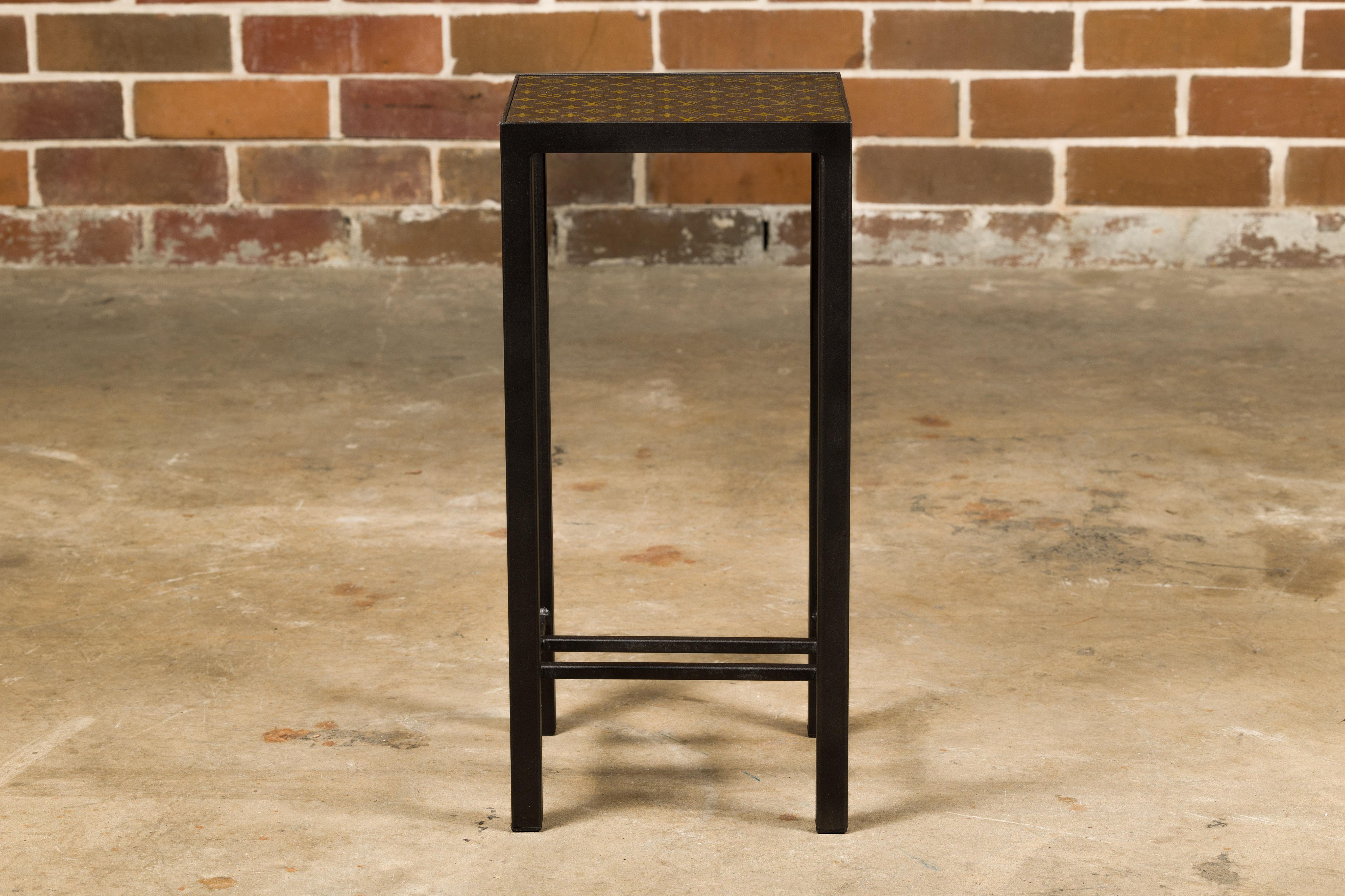 Petite table d'appoint avec un plateau en cuir Louis Vuitton monté sur une base en métal personnalisée avec des traverses. Plongez dans le summum du luxe et de l'artisanat avec cette étonnante petite table d'appoint, dont le plateau est orné du cuir