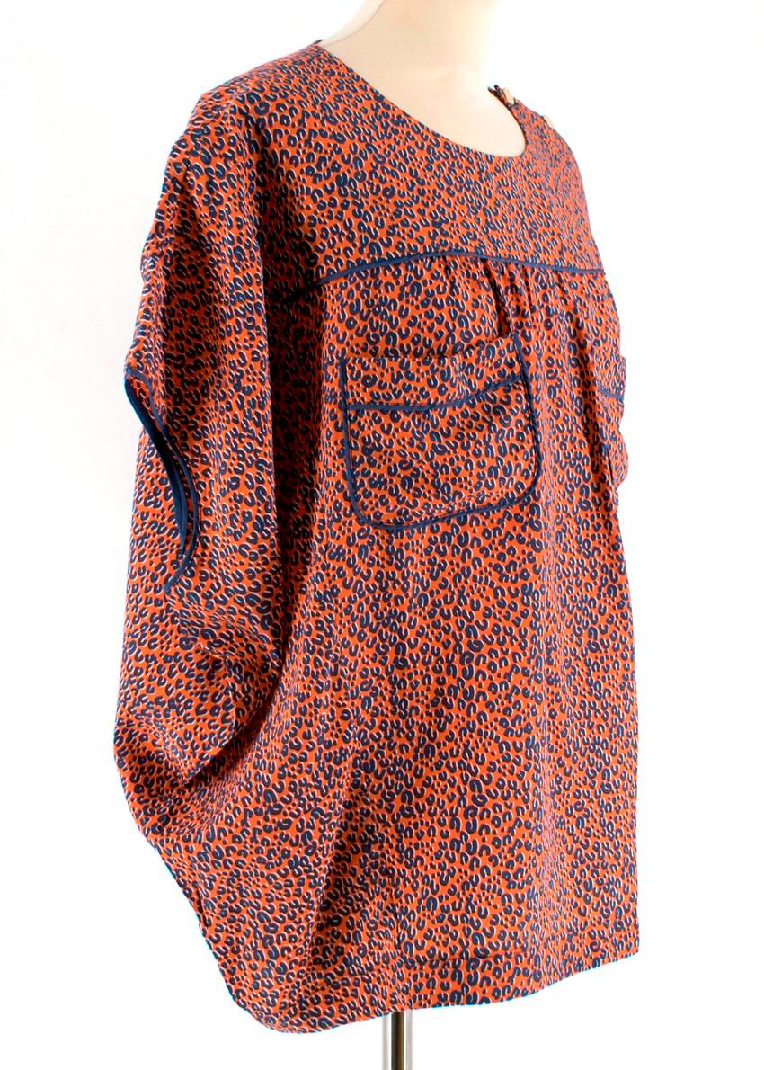Louis Vuitton Animal Print Silk Orange Blouse. RRP £1195

- Short-Sleeved
- Gold Tone Button Detail at Shoulder 
- Two Chest Pocket Details 
- Blue and Red Animal Print all over 
- Rounded Neckline 
- Straight Hemline 

Materials 
100% Silk 

Dry