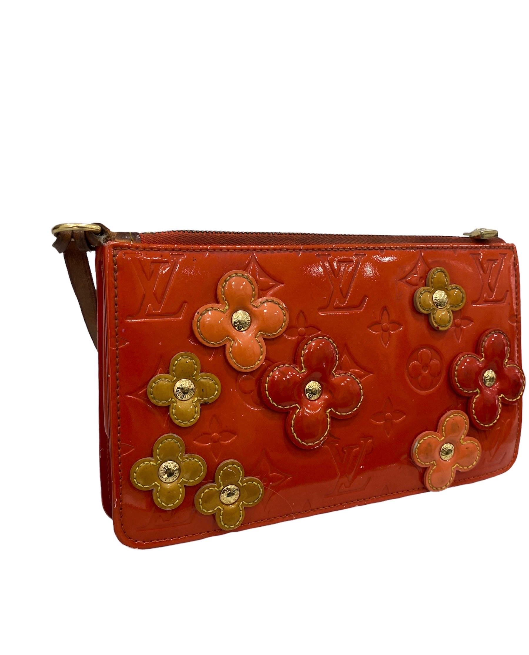 Louis Vuitton clutch bag, Lexington model, made of orange patent leather with raised flowers, cowhide inserts and golden hardware.

Equipped with a zip closure, internally lined in orange leather, roomy for the essentials.

Equipped with a thin
