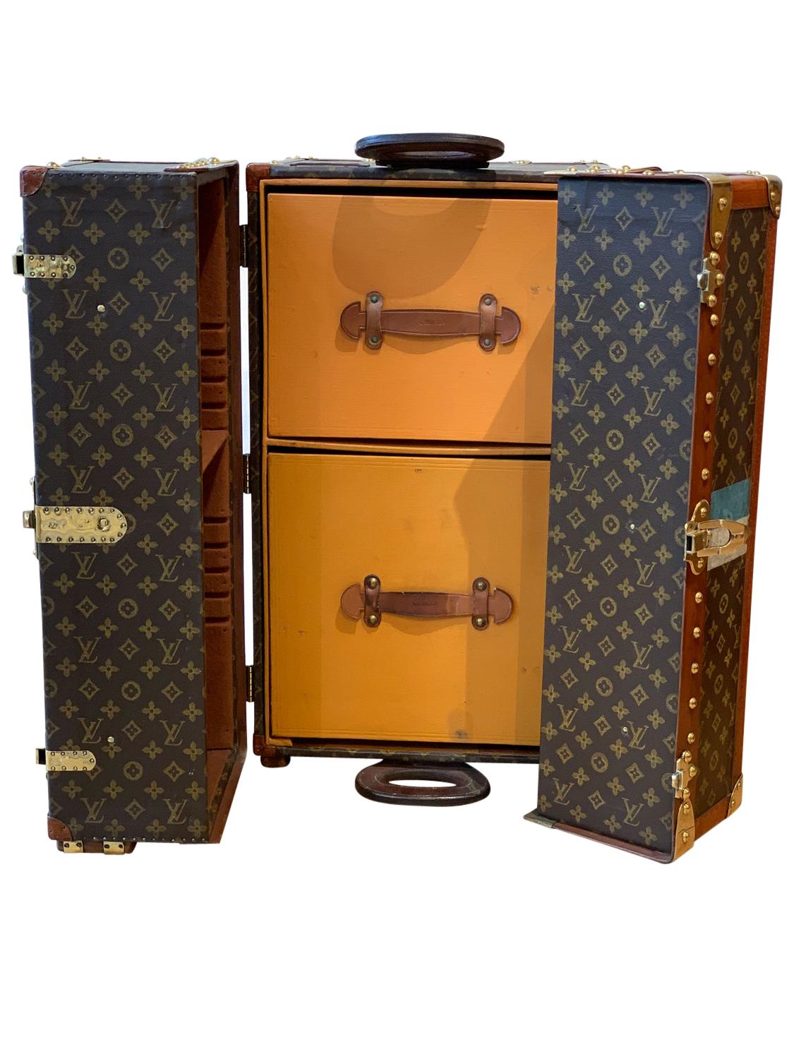 A Louis Vuitton library trunk, circa 1920 in monogrammed canvas with the initials S.C. and the number 8. The trunk opens on it’s end to a central compartment with two drawers for files, the left door with Louis Vuitton canvas straps is for books and