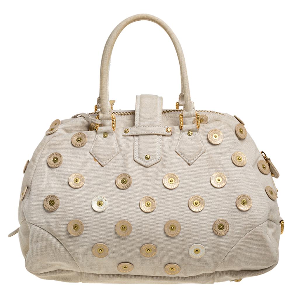 Louis Vuitton's handbags are popular owing to their high style and functionality. Crafted from monogram canvas, this bowly bag has a beautiful polka dot design all over. The pretty bag features dual top handles, a tag and the bag has a top zip