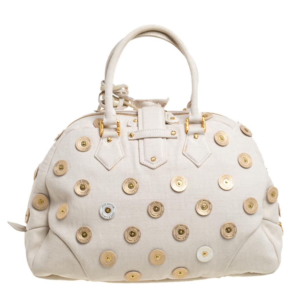 Louis Vuitton's handbags are popular owing to their high style and functionality. Crafted from canvas, this Bowly Panama bag has a beautiful polka dot design all over. The pretty bag features dual top handles, a tag, a textured S lock on the front,