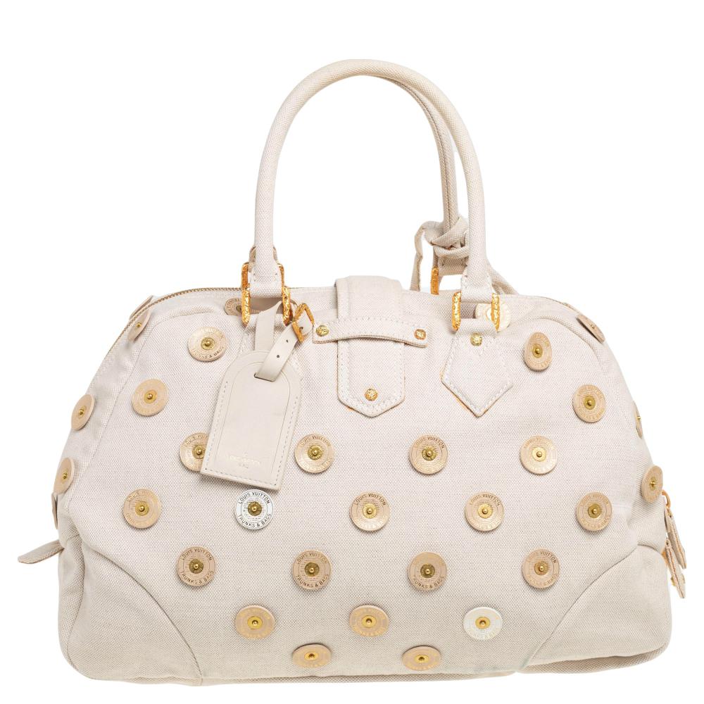 Louis Vuitton's handbags are popular owing to their high style and functionality. Crafted from canvas, this Bowly bag has a beautiful polka dot design all over. The pretty bag features dual top handles, a tag and the bag has a top zip closure that