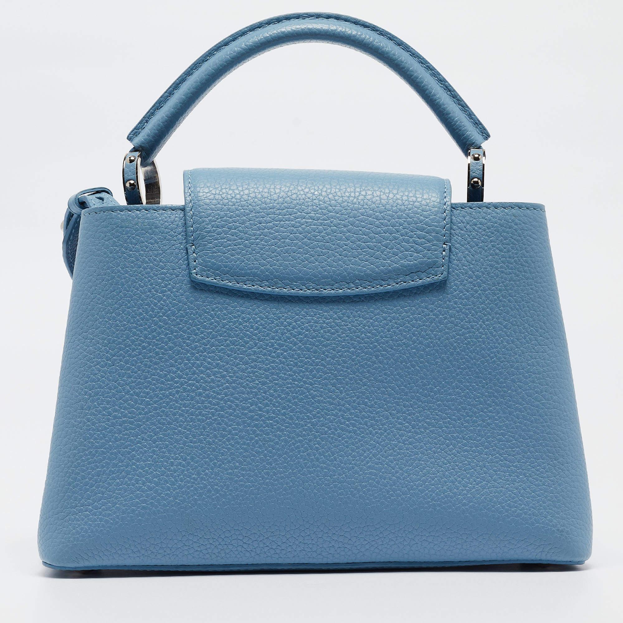 Crafted with finesse, the Louis Vuitton Capucines BB Bag exudes charm and artistry. Its delicate light blue leather, adorned with a mechanical flower charms, captivates attention effortlessly. With meticulous craftsmanship and iconic LV detailing,