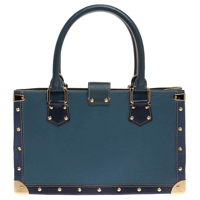 Louis Vuitton's Le Fabuleux bag looks nothing like a regular Louis Vuitton bag! Rectangular in shape, the bag is crafted from blue Suhali leather into a structured silhouette and has stud embellishments all over. It features dual top handles, a