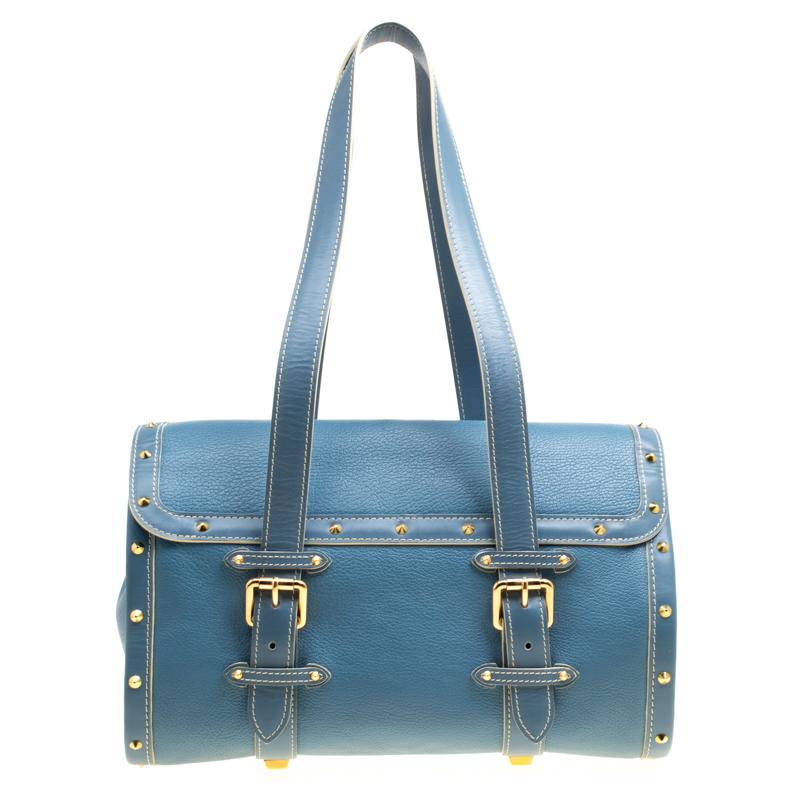 This L'Epanoui GM bag from Louis Vuitton is gorgeous. The beauty in alight blue hue is crafted from leather and flaunts a unique and distinctive style. It features beautiful gold-tone studs outlining the bag in an orderly fashion, a push lock