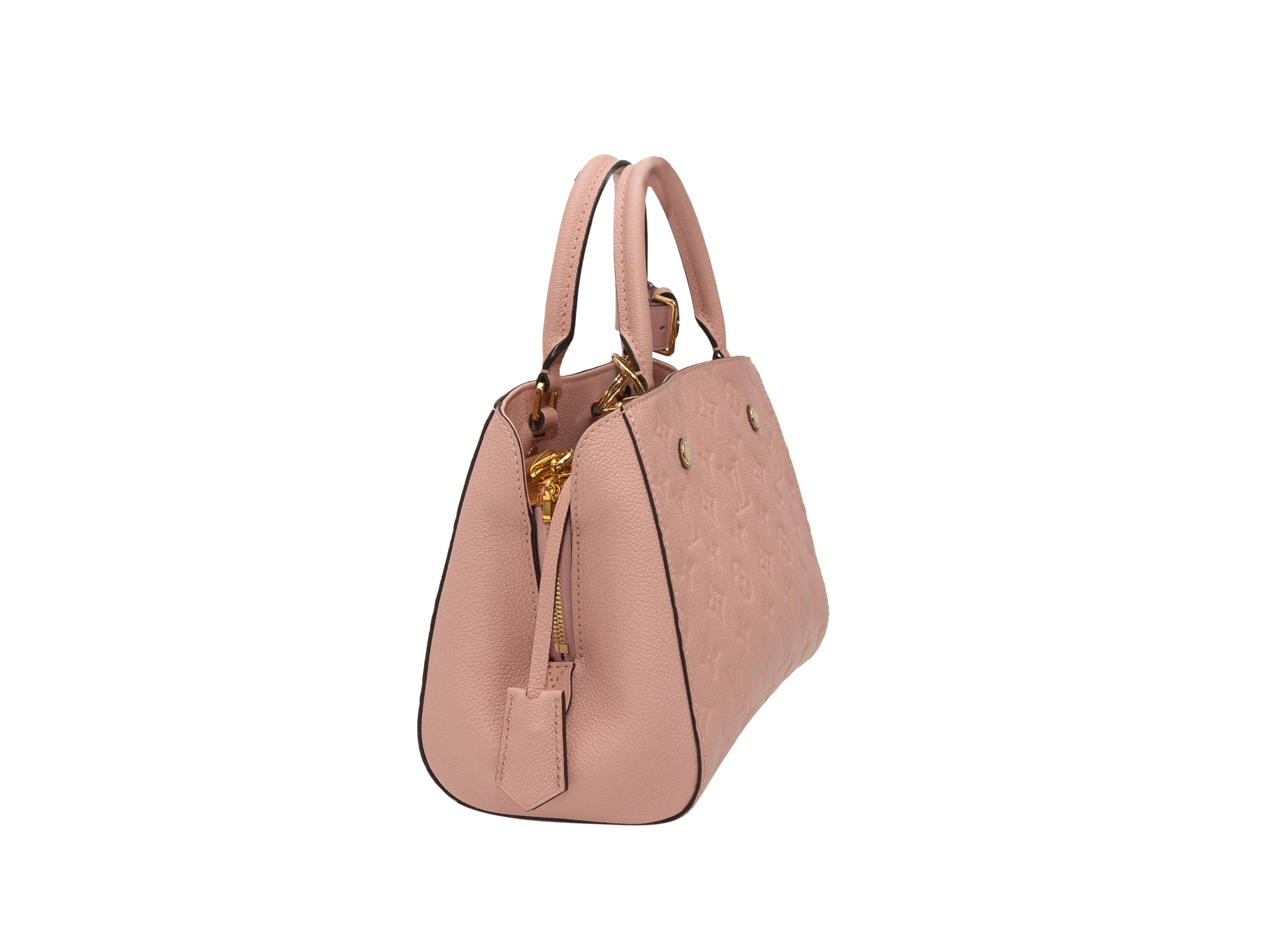Product details: Light pink monogram leather Empreinte Montaigne PM bag by Louis Vuitton. Gold-tone hardware. Dual rolled top handles. Optional shoulder strap. Zip closure at top. 13.5