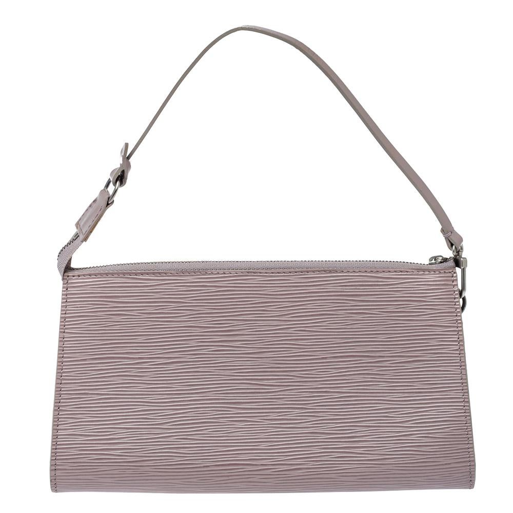 Rendered in lilac epi leather, this elegant pochette from the house of Louis Vuitton is the perfect choice if you're looking for a mini bag that fits in your phone and cards. It is complete with a shoulder strap making it easy to carry along at any