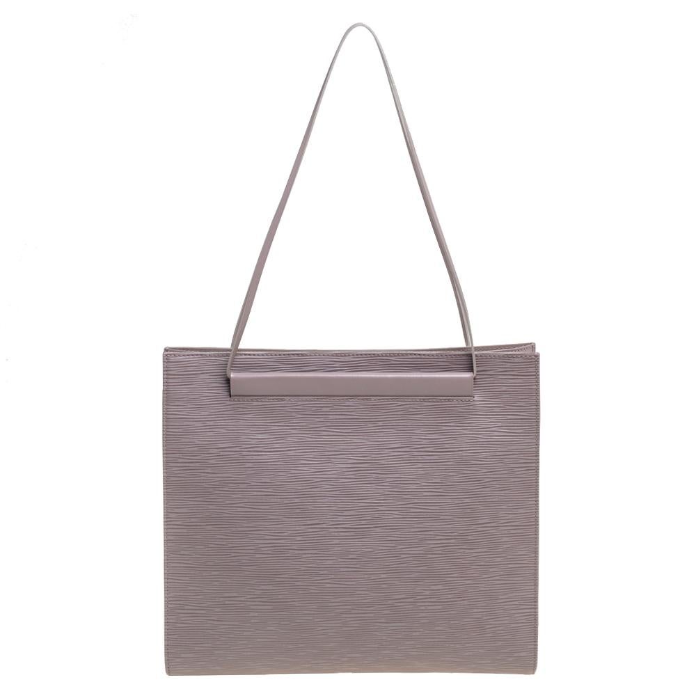 Structured into a neat silhouette, this Saint Tropez shoulder bag from the House of Louis Vuitton will add an element of luxury and elegance to your attire. It is made from lilac Epi leather and features two handles. It has silver-toned hardware and