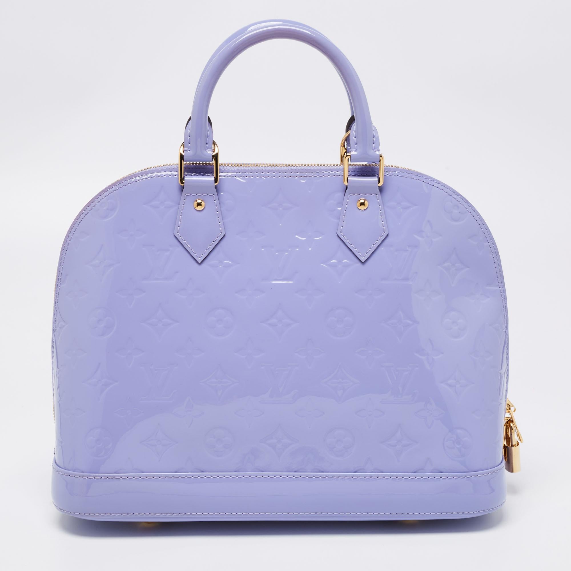 Out of all the irresistible handbags from Louis Vuitton, the Alma is the most structured one. It is a classic that has received love from fashion icons. This piece comes crafted from lilac-hued patent leather, featuring a zip closure with a padlock