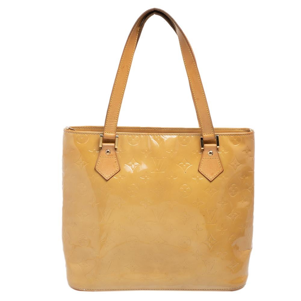 Ce sac Houston de Louis Vuitton est conçu de manière élégante avec une finition finement dessinée. Confectionné en Monogram Vernis, il est orné d'une quincaillerie de couleur dorée et présente des poignées en cuir plates à double sommet. L'intérieur