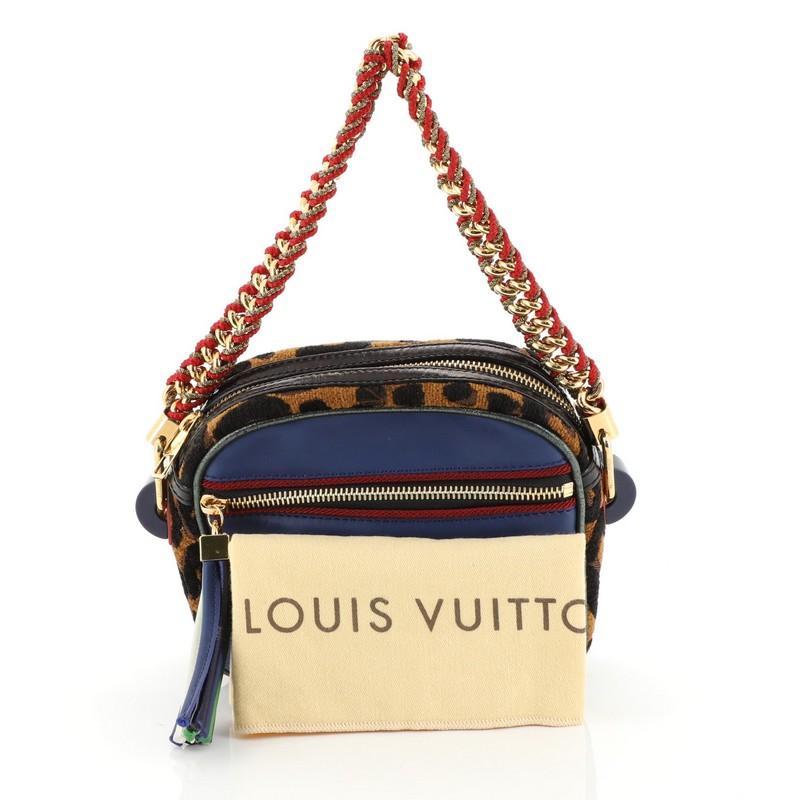 This Louis Vuitton Limited Edition Flight Bag Savane Calfskin and Leopard Chenille, crafted in blue leather, features chain shoulder strap threaded with fabric, exterior front zip pocket, perforated logo and gold-tone hardware. Its top zip closure