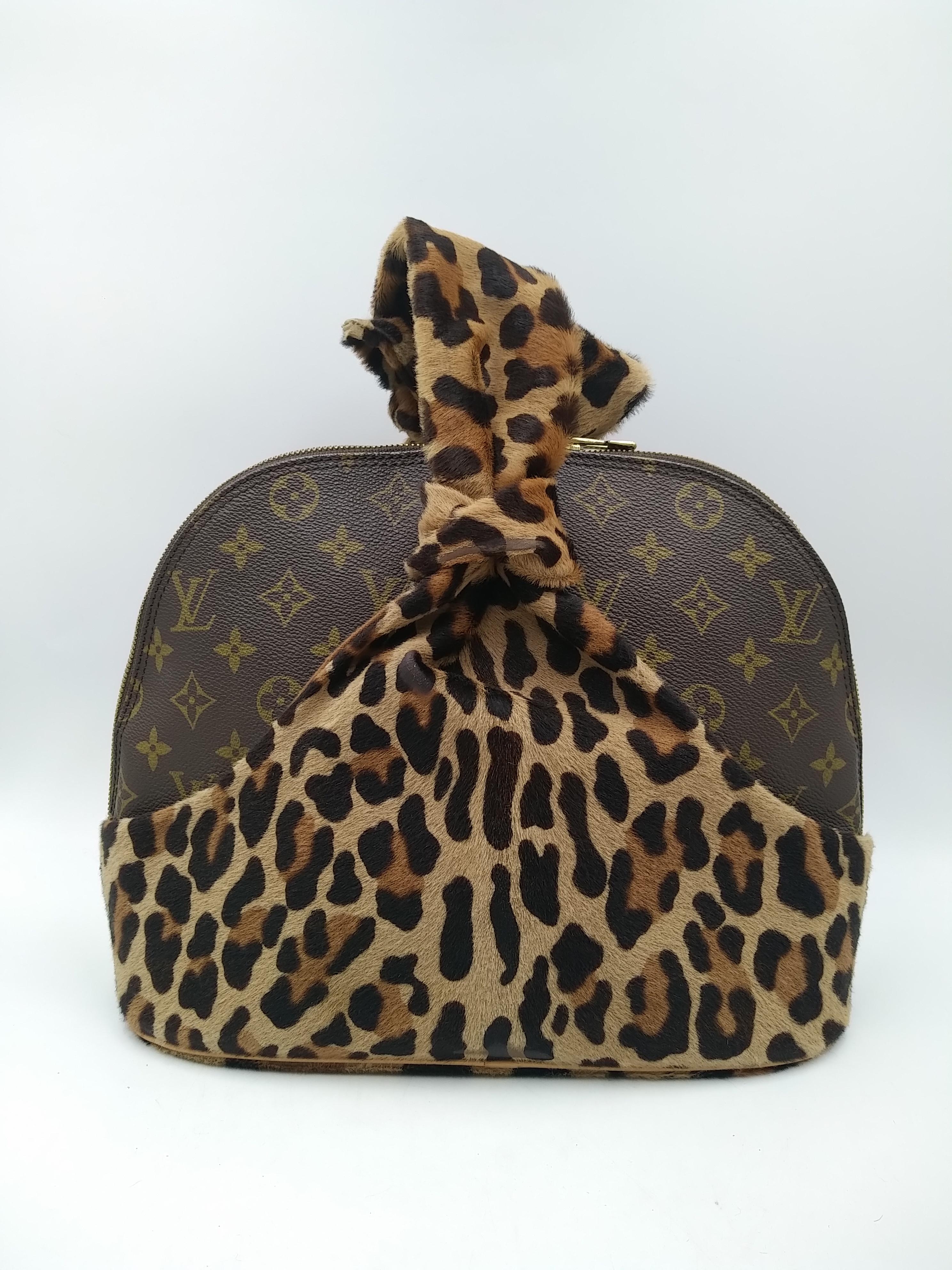 Louis Vuitton Limited Edition Monogram Canvas and Leopard Print Calf Hair Centenaire Alma Bag by Azzedine Alaïa, 1996.
- 100% authentic Louis Vuitton
- Monogram coated canvas and leopard print calf hair
- Three flat pockets underneath the calf