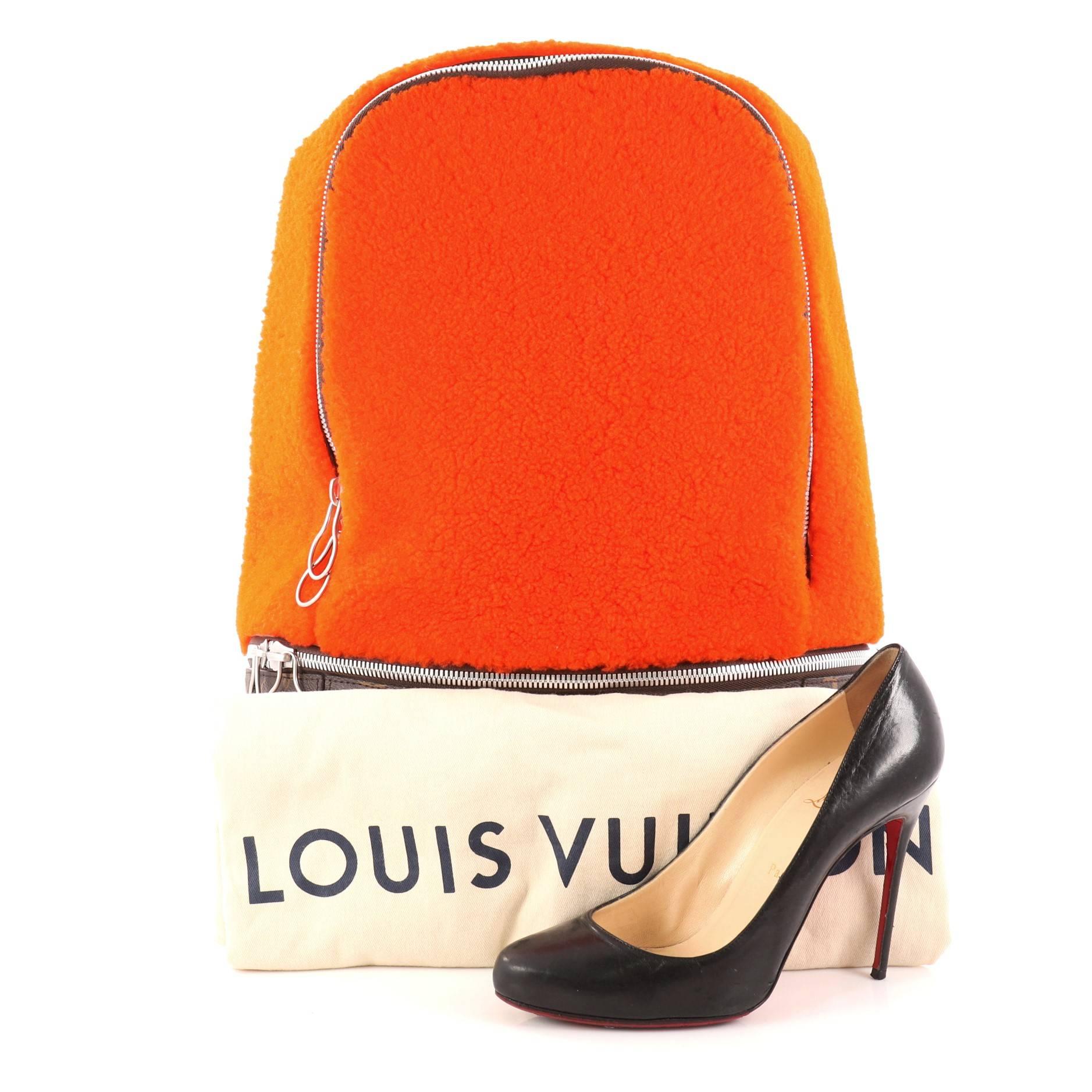 This authentic Louis Vuitton Limited Edition Marc Newson Backpack Shearling and Monogram Canvas is a refined backpack that displays luxury and style. Crafted in orange shearling and brown monogram coated canvas, this bag features fleece shoulder