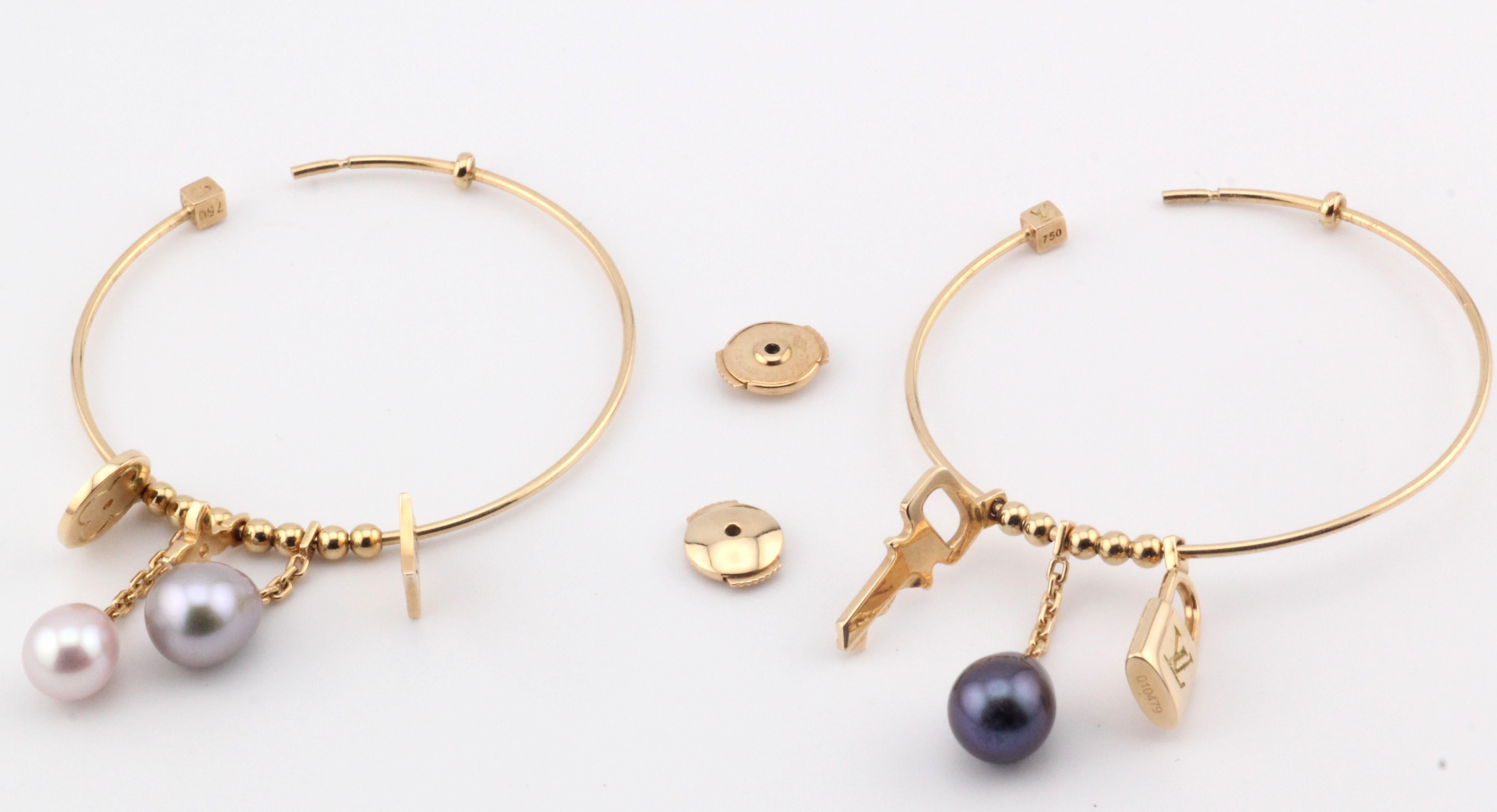 The Louis Vuitton Lock Key Charm Pearl 18k Yellow Gold Hoop Earrings are a sophisticated blend of luxury, elegance, and playful charm. Crafted from radiant 18k yellow gold, these hoops showcase Louis Vuitton's signature artistry in fine