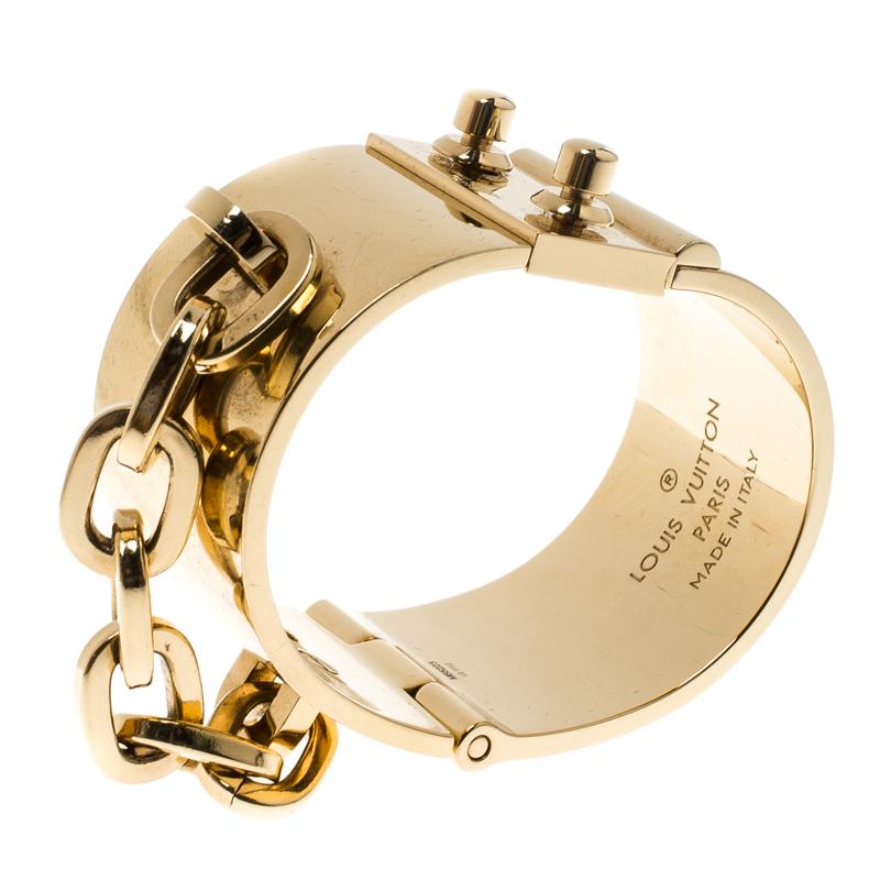 This Lock Me Manchette cuff bracelet from Louis Vuitton, exuding a bold finish, will be your new favourite statement accessory. Constructed with gold-tone metal, it features a thick chain accent to the side and a slide lock clasp closure. It has a