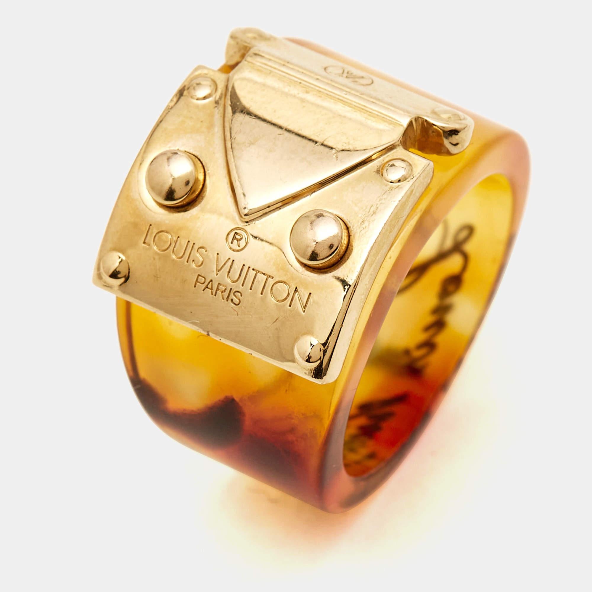 From Louis Vuitton's popular 'Lock Me' collection comes this chic brown ring. It is crafted from resin and is finished with gold-tone metal.

Includes: Original Box, Original Dustbag, Info Booklet