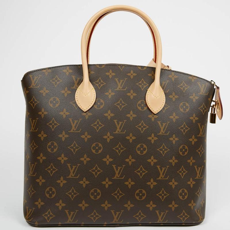 Large Lockit bag from the House of LOUIS VUITTON in brown Monogram coated canvas closed with a zip. The finishes are in natural cowhide leather with a golden trim. It is worn by hand. It is lined in plum leather, a large zipped pocket as well as two
