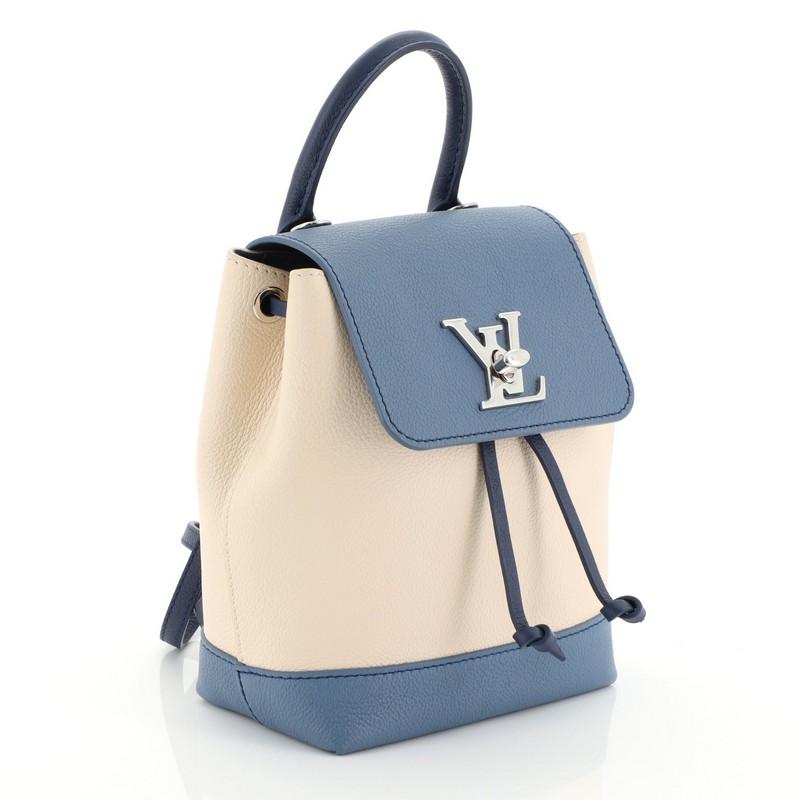 This Louis Vuitton Lockme Backpack Leather Mini, crafted in blue and neutral leather, features a leather top handle, adjustable shoulder straps, and silver-tone hardware. Its turn-lock and drawstring closure opens to a blue microfiber interior with