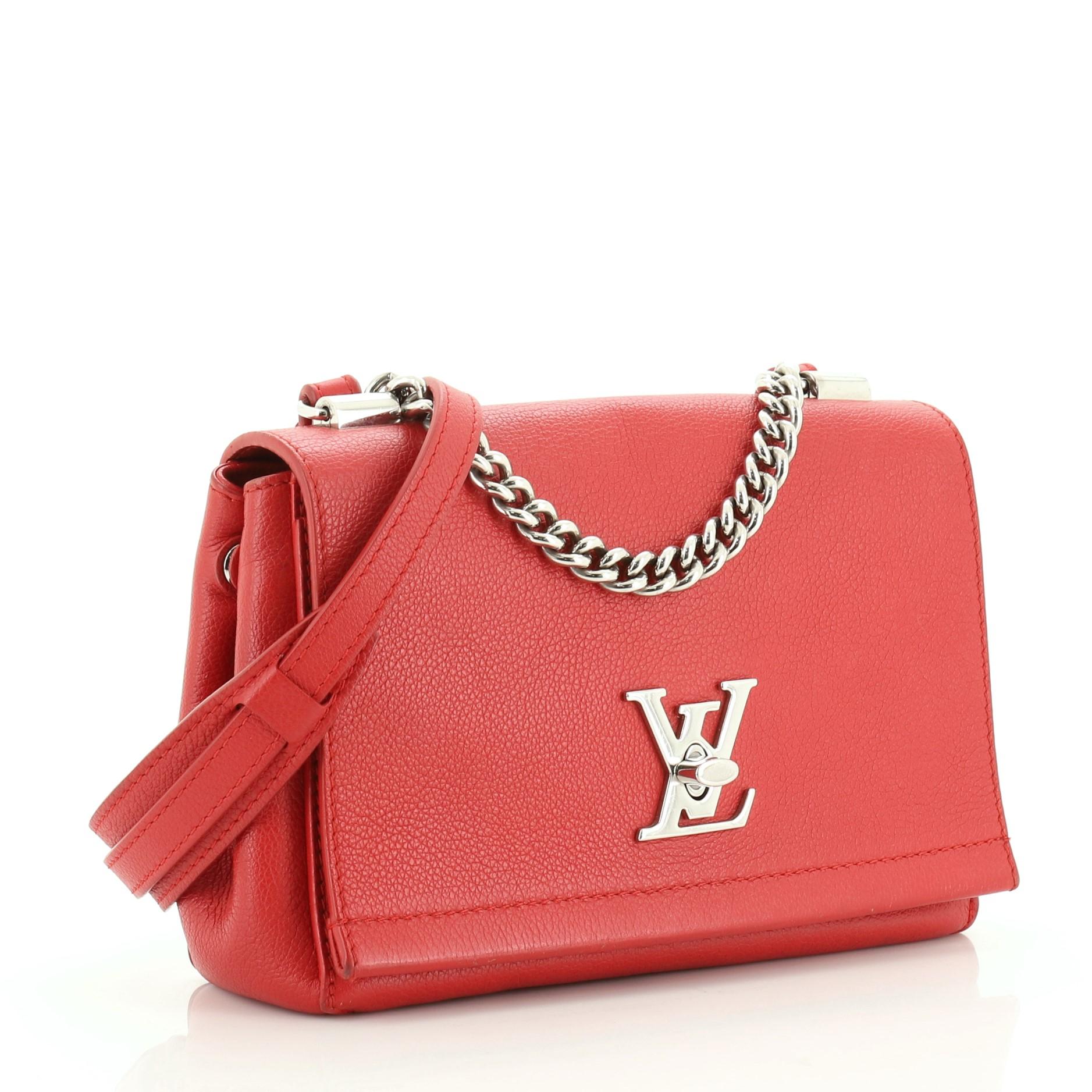 This Louis Vuitton Lockme II Handbag Leather BB, crafted from red leather, features a short chain link handle, leather shoulder strap, side snap buttons, and silver-tone hardware. Its turn-lock closure opens to a red fabric interior. Authenticity