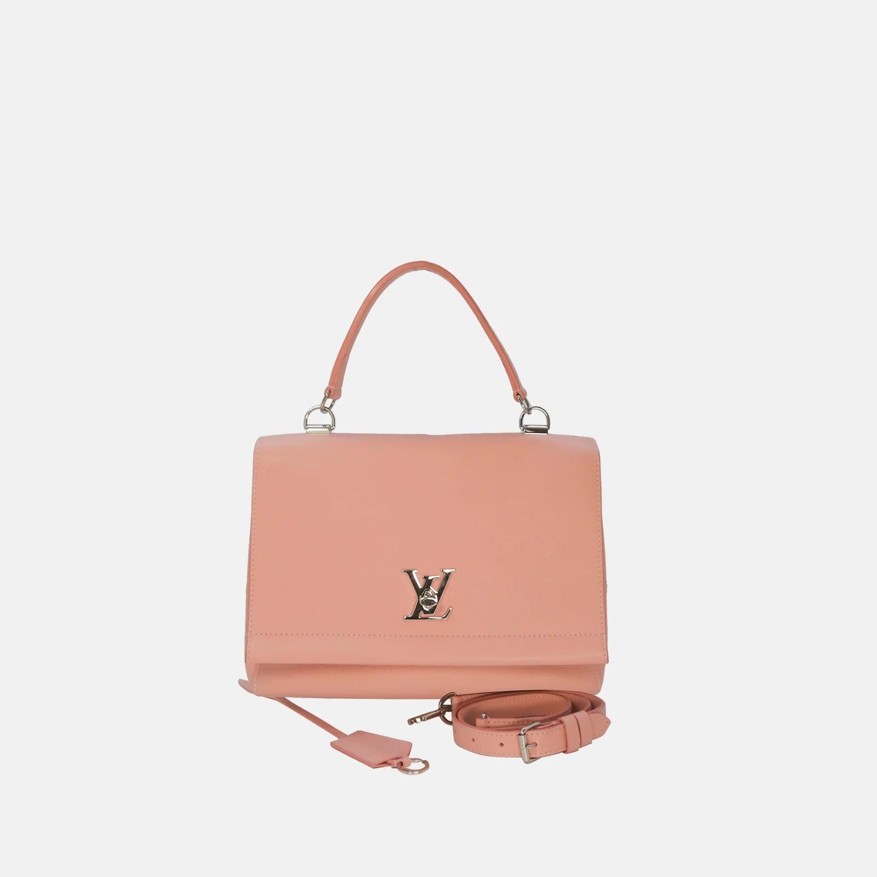 Elegant and versatile, the Louis Vuitton Lockme II Crossbody Bag in soft pink calf leather is a refined statement piece. Featuring the signature LV turn-lock closure, it exudes timeless sophistication. Designed for practicality, it offers multiple