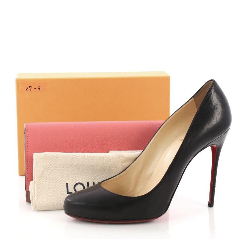 This Louis Vuitton Lockme II Wallet Calfskin, crafted in pink and mauve calfskin leather, features a front flap and silver-tone hardware. Its snap closure opens to a mauve leather and fabric interior with multiple card slots and center zip pocket.