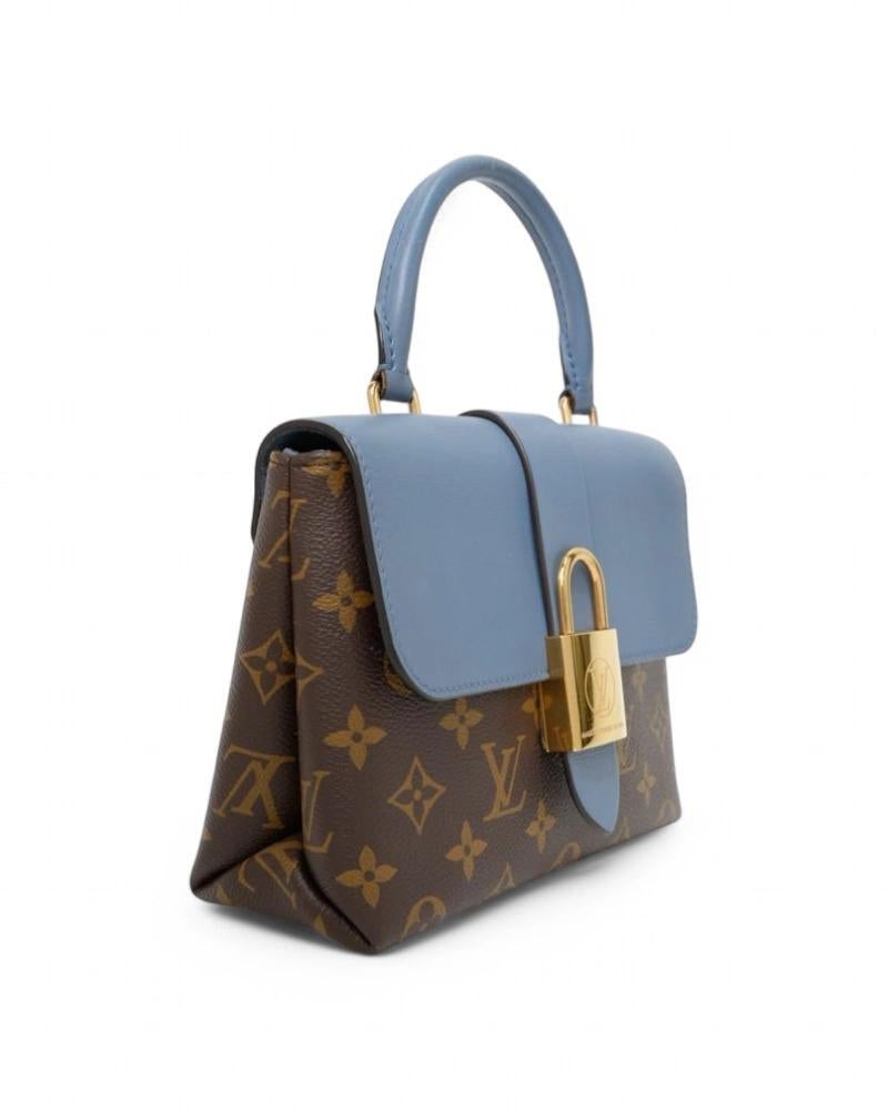 Louis Vuitton signature bag, model Locky in size BB, made of brown canvas in classic monogram pattern with blue leather inserts and gold hardware. Featuring a flap with a magnetic button, internally lined in blue suede fabric with convenient pocket,