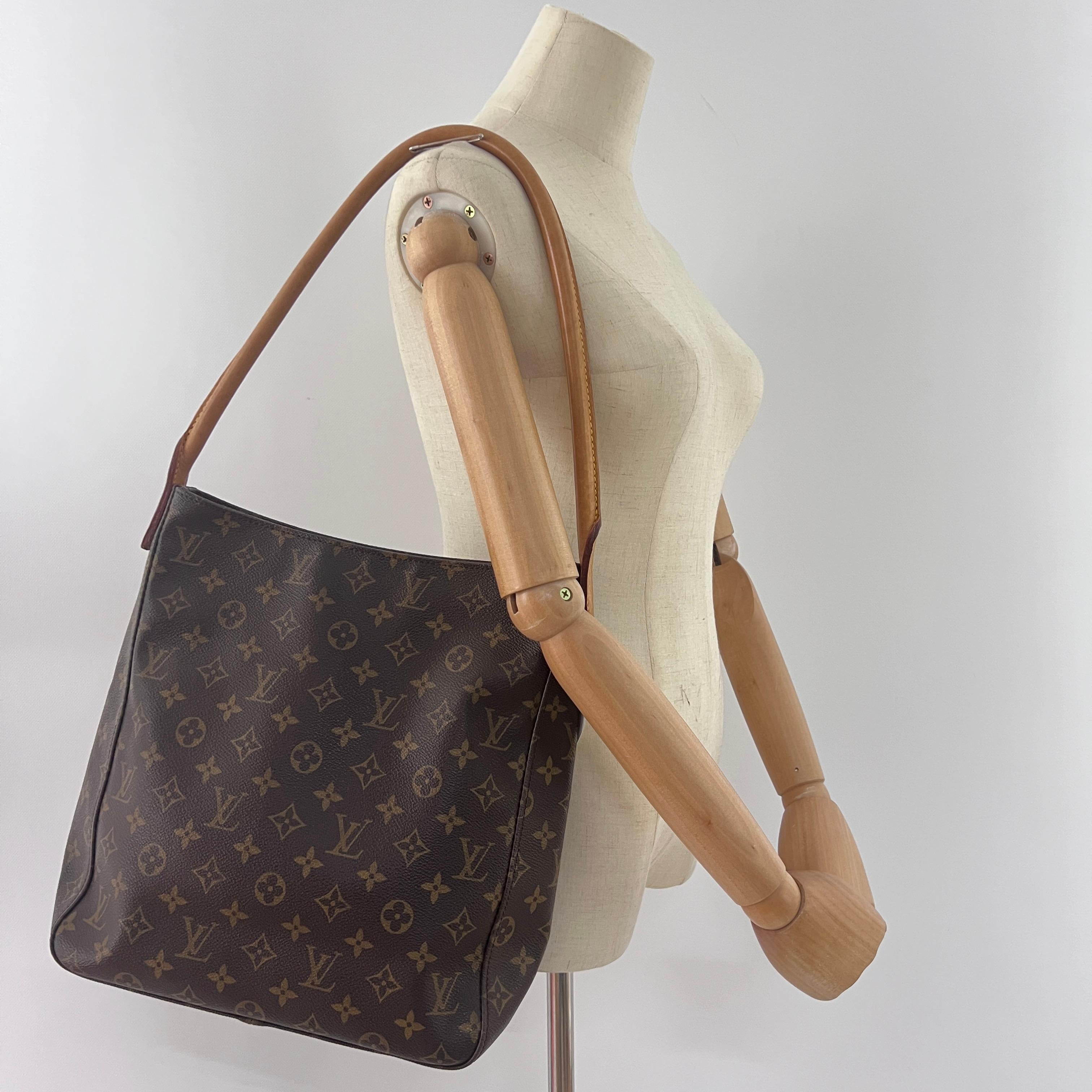 LOUIS VUITTON GM Looping en toile et cuir marron, avec des accessoires en métal doré. Le sac est muni d'une fermeture à glissière. L'intérieur se compose d'un compartiment principal, d'une poche plate et d'une poche plate zippée. Peut être porté à