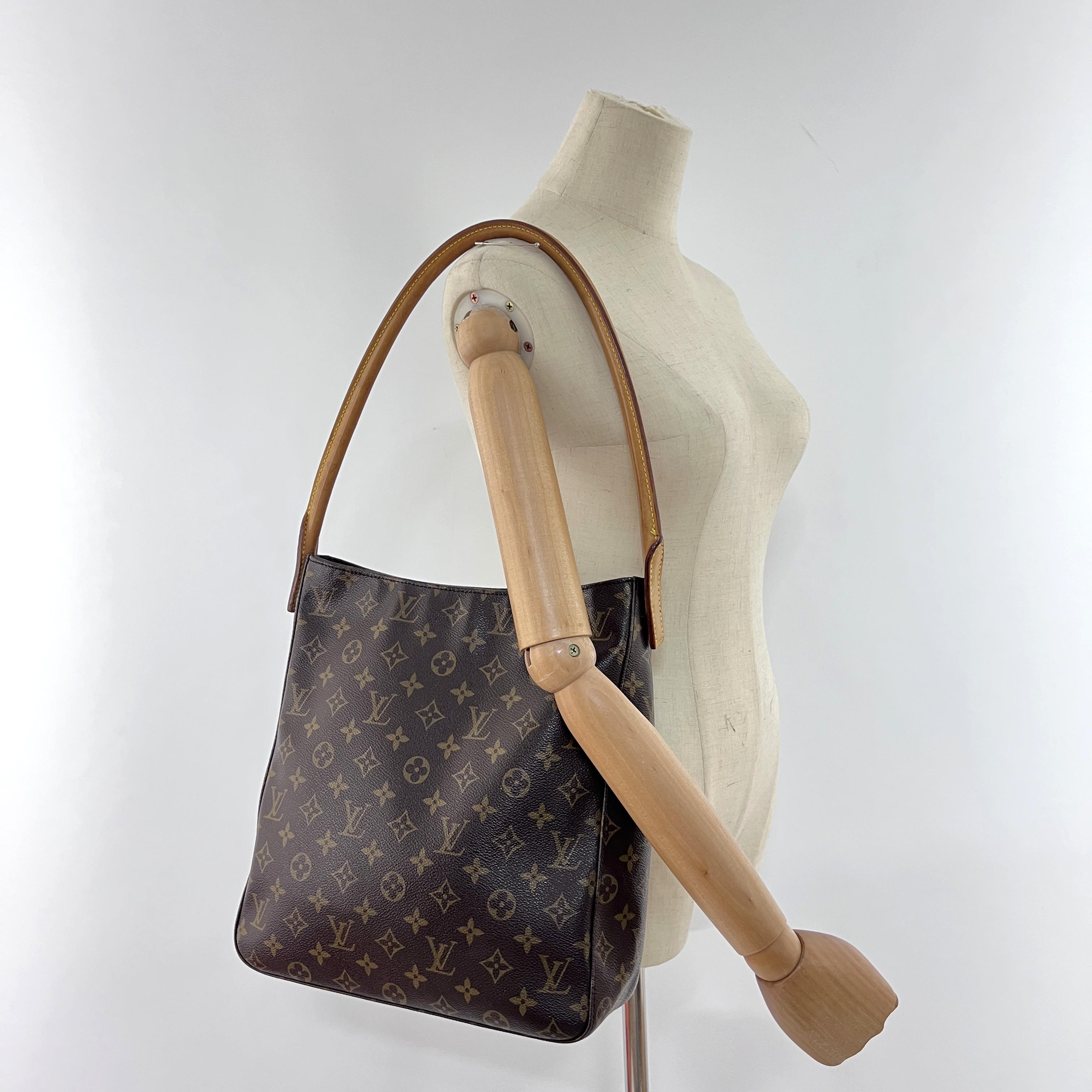 LOUIS VUITTON GM Looping en toile et cuir marron, avec des accessoires en métal doré. Le sac est muni d'une fermeture à glissière. L'intérieur se compose d'un compartiment principal, d'une poche et d'une poche plate zippée. Peut être porté à