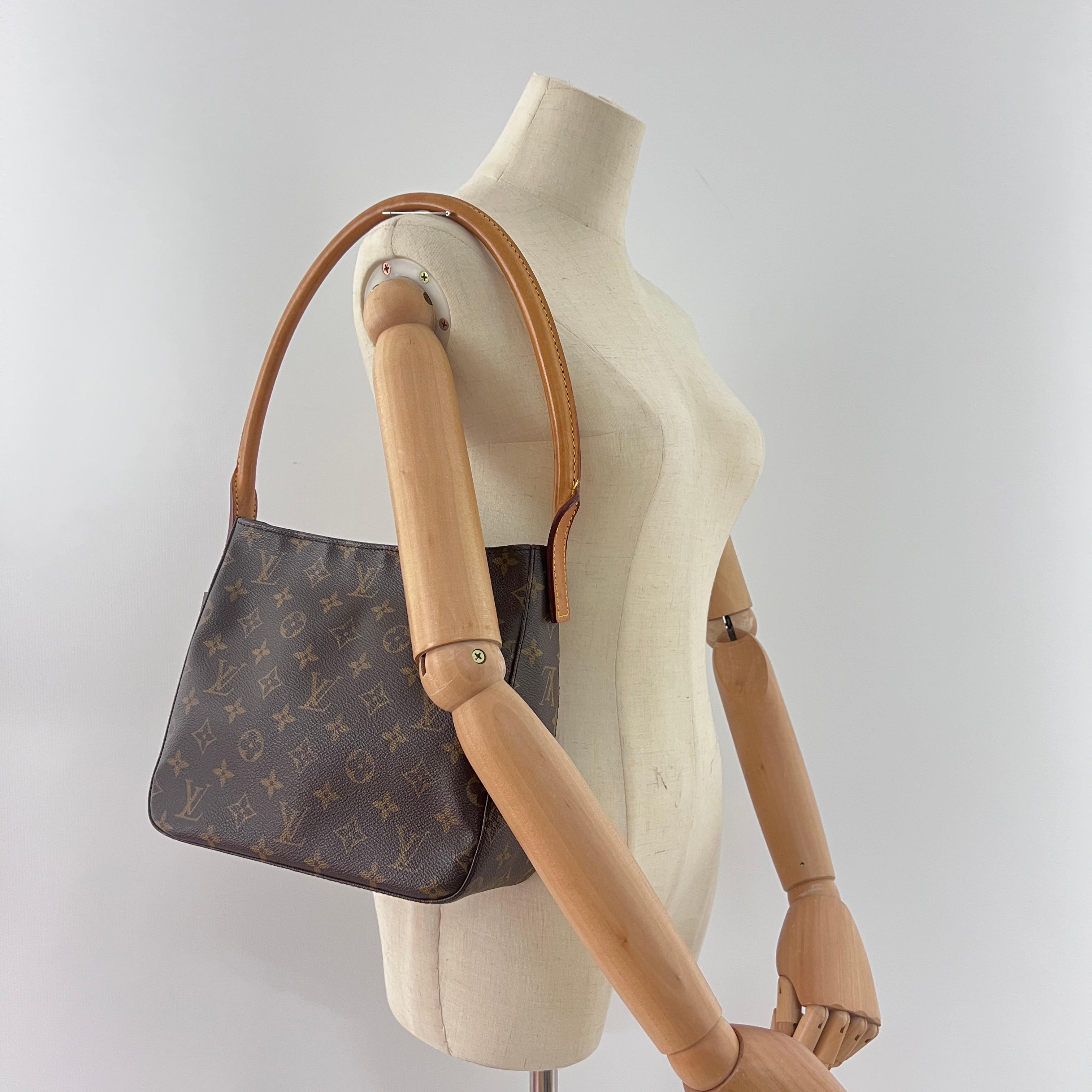 LOUIS VUITTON MM Looping en toile et cuir marron, avec des accessoires en métal doré. Le sac est muni d'une fermeture à glissière. L'intérieur se compose d'un compartiment principal, d'une poche plate et d'une poche plate zippée. Peut être porté à