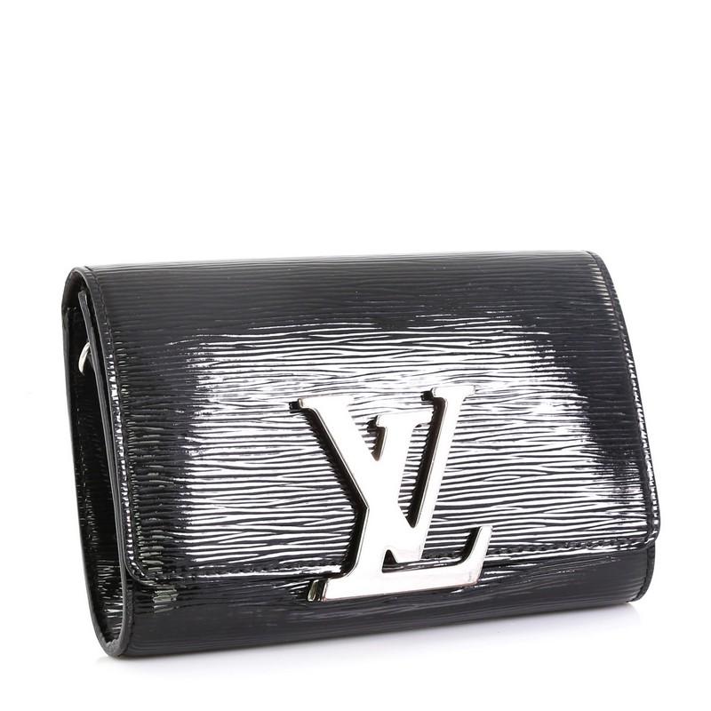This Louis Vuitton Louise Shoulder Bag Electric Epi Leather PM, crafted in black electric epi leather, features an oversized silver resin LV logo, detachable leather strap and silver-tone hardware. Its flip clasp closure opens to a black microfiber