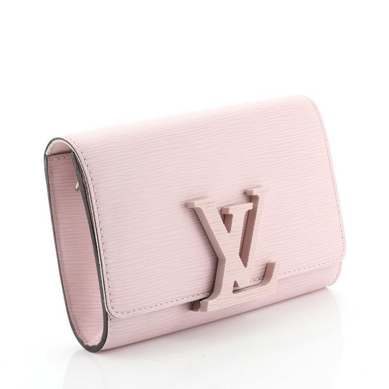 This Louis Vuitton Louise Shoulder Bag Epi Leather PM, crafted from pink epi leather, features an oversized resin LV logo, leather strap and silver-tone hardware. Its flip clasp closure opens to a pink microfiber interior with side zip and slip