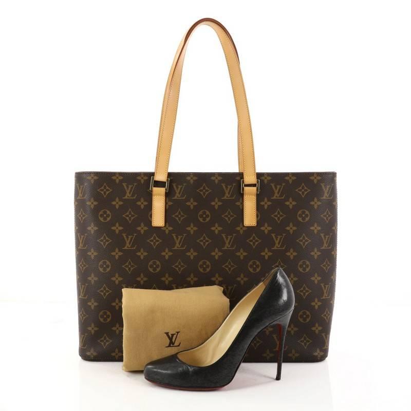 This authentic Louis Vuitton Luco Handbag Monogram Canvas is a classic tote that displays fashion and functionality all rolled into one. Crafted with the brand's iconic brown monogram coated canvas, this tote features dual flat leather handles, a