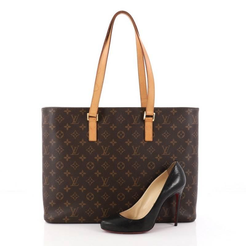 This authentic Louis Vuitton Luco Handbag Monogram Canvas is a classic tote that displays fashion and functionality all rolled into one. Crafted with the brand's iconic brown monogram coated canvas, this tote features dual flat leather handles, a