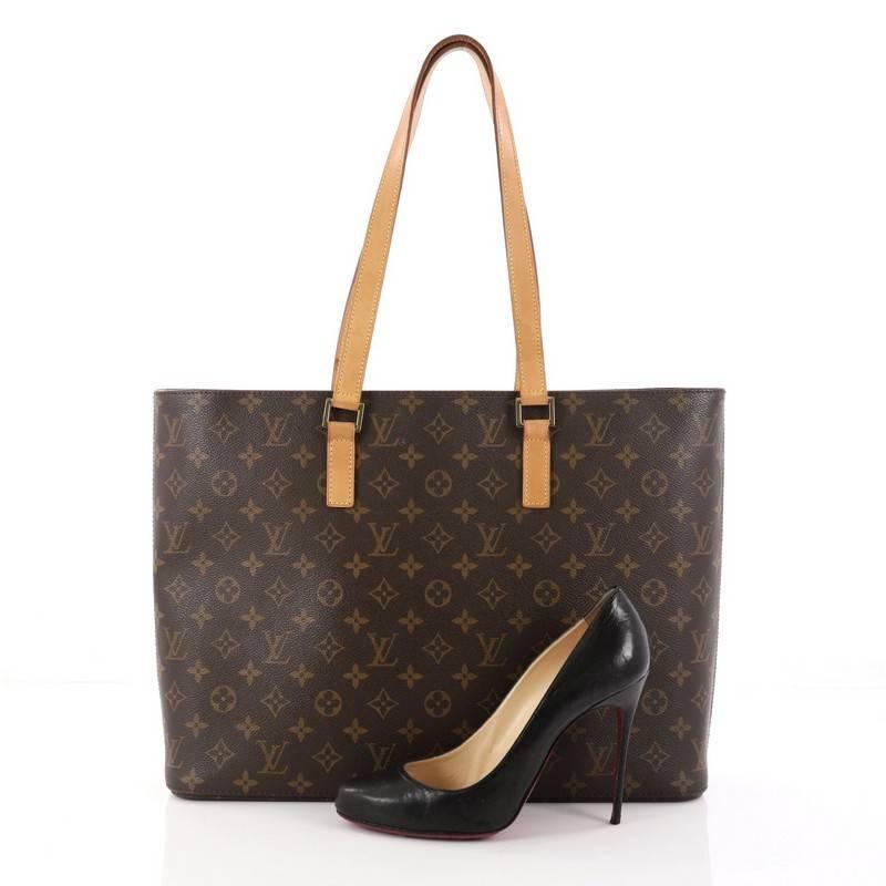 This authentic Louis Vuitton Luco Handbag Monogram Canvas is a classic tote that displays fashion and functionality all rolled into one. Crafted with the brand's iconic brown monogram coated canvas, this tote features dual flat leather handles, a