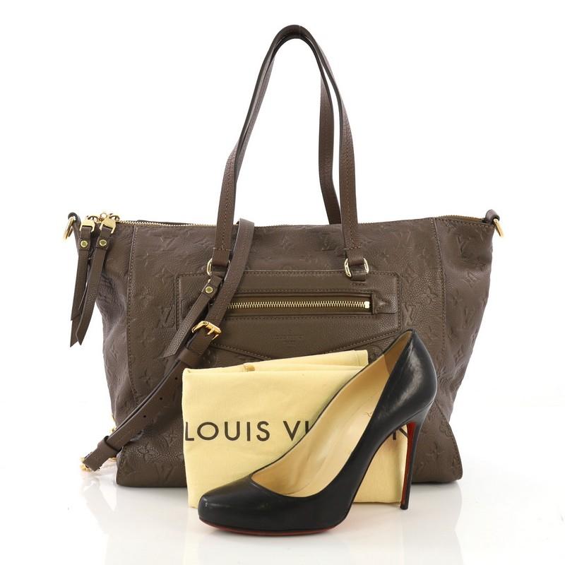 This Louis Vuitton Lumineuse Handbag Monogram Empreinte Leather PM, crafted in taupe monogram empreinte leather, features an exterior front zip pocket, dual flat handles, and gold-tone hardware. Its top zip closure opens to a brown fabric interior