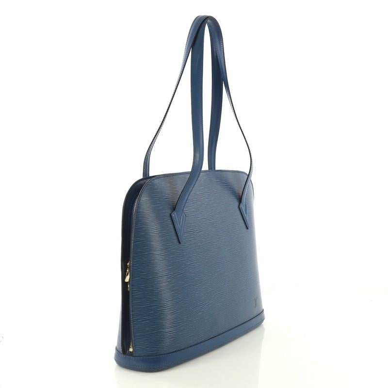 This Louis Vuitton Lussac Handbag Epi Leather, crafted in blue epi leather, features dual flat leather straps, subtle LV logo, and gold-tone hardware. Its two-way zip closure opens to a blue microfiber interior with zip and slip pockets.