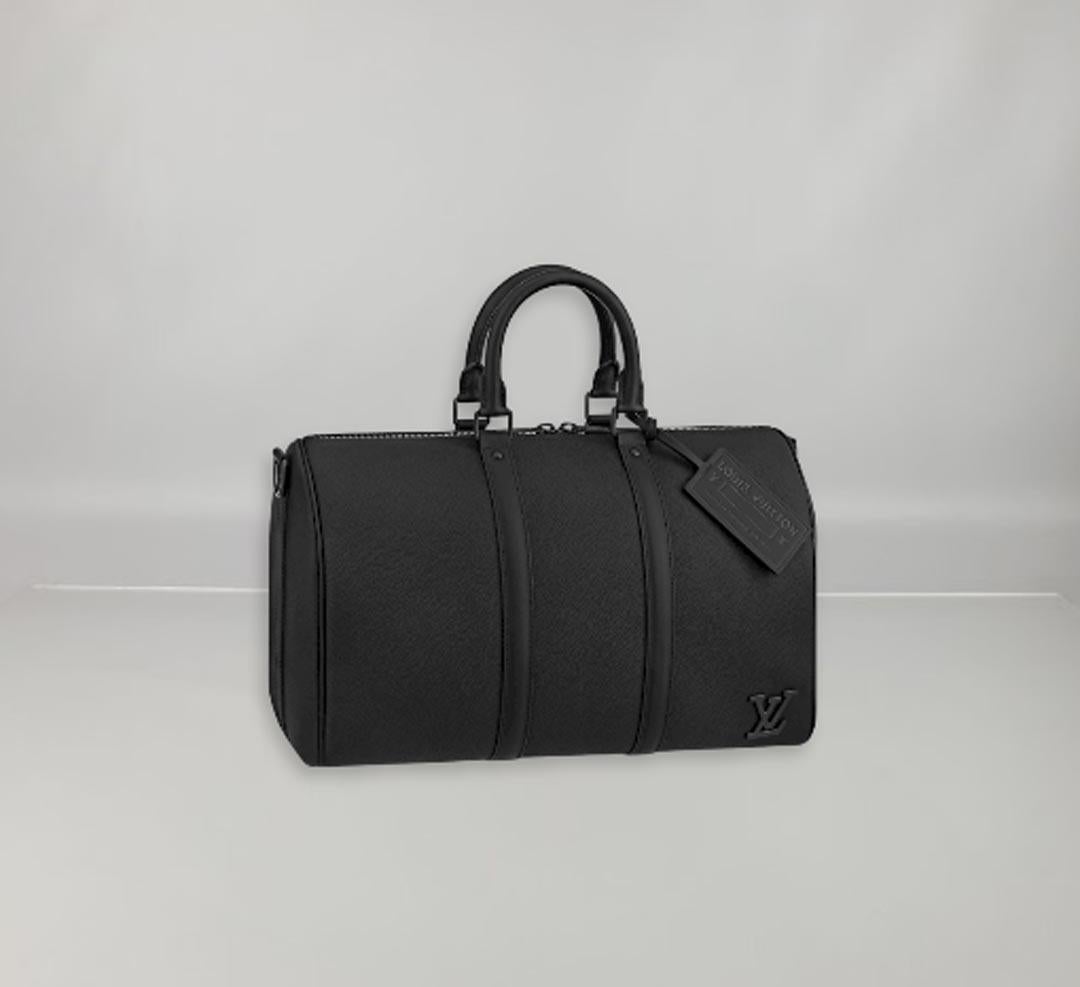 The new LV Aerogram version of the Keepall bag exudes low-key chic in soft, finely grained black cowhide. A host of discreet details, like the black metal 'LV' initials, a customisable leather tag and a removable jacquard strap, give it an