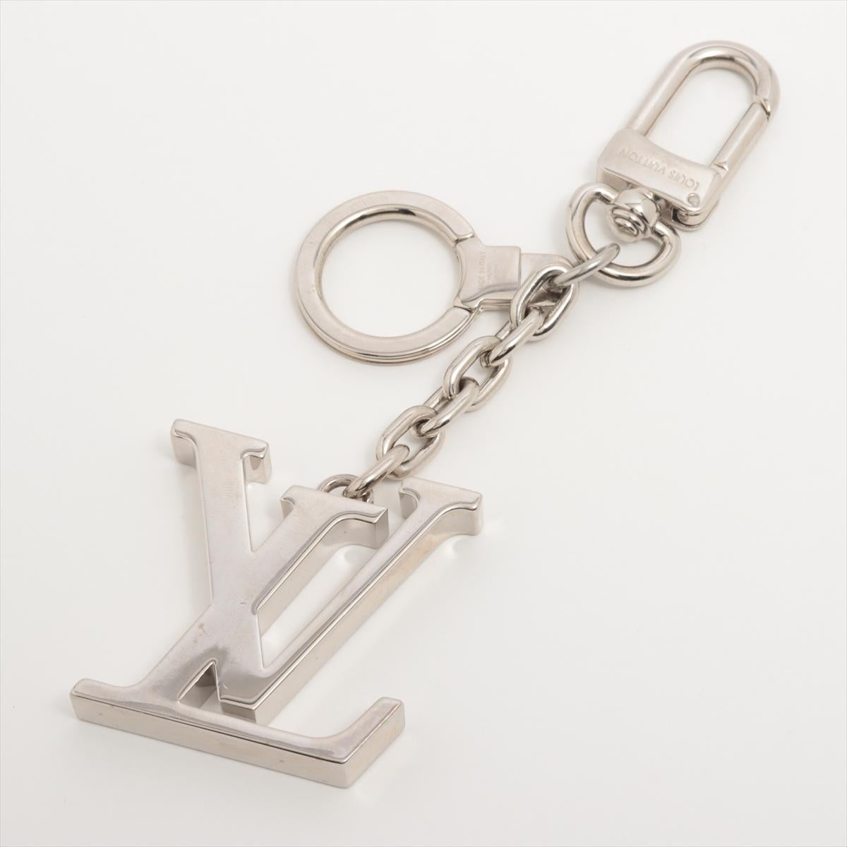The Louis Vuitton LV Initials Bag Charm is a stylish and sophisticated accessory that adds a touch of luxury to any handbag. Crafted from high-quality materials, the bag charm features the iconic LV initials logo in silver-tone hardware. It comes