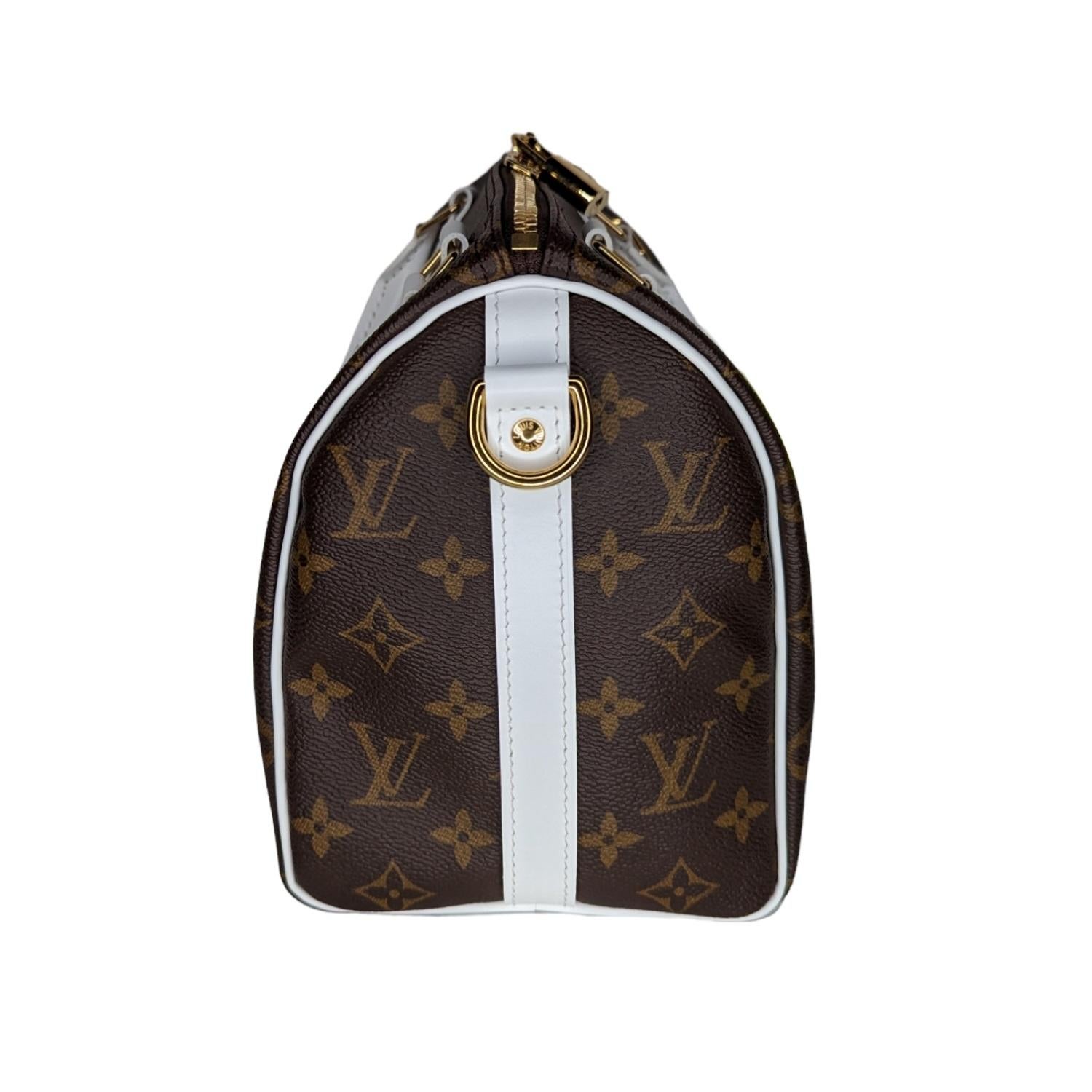 Ce sac à main classique est réalisé en toile monogramme signée Louis Vuitton. Le sac à bandoulière présente des poignées supérieures roulées en cuir de vachette blanc, une bandoulière réglable en option et des accessoires en laiton poli, ainsi qu'un