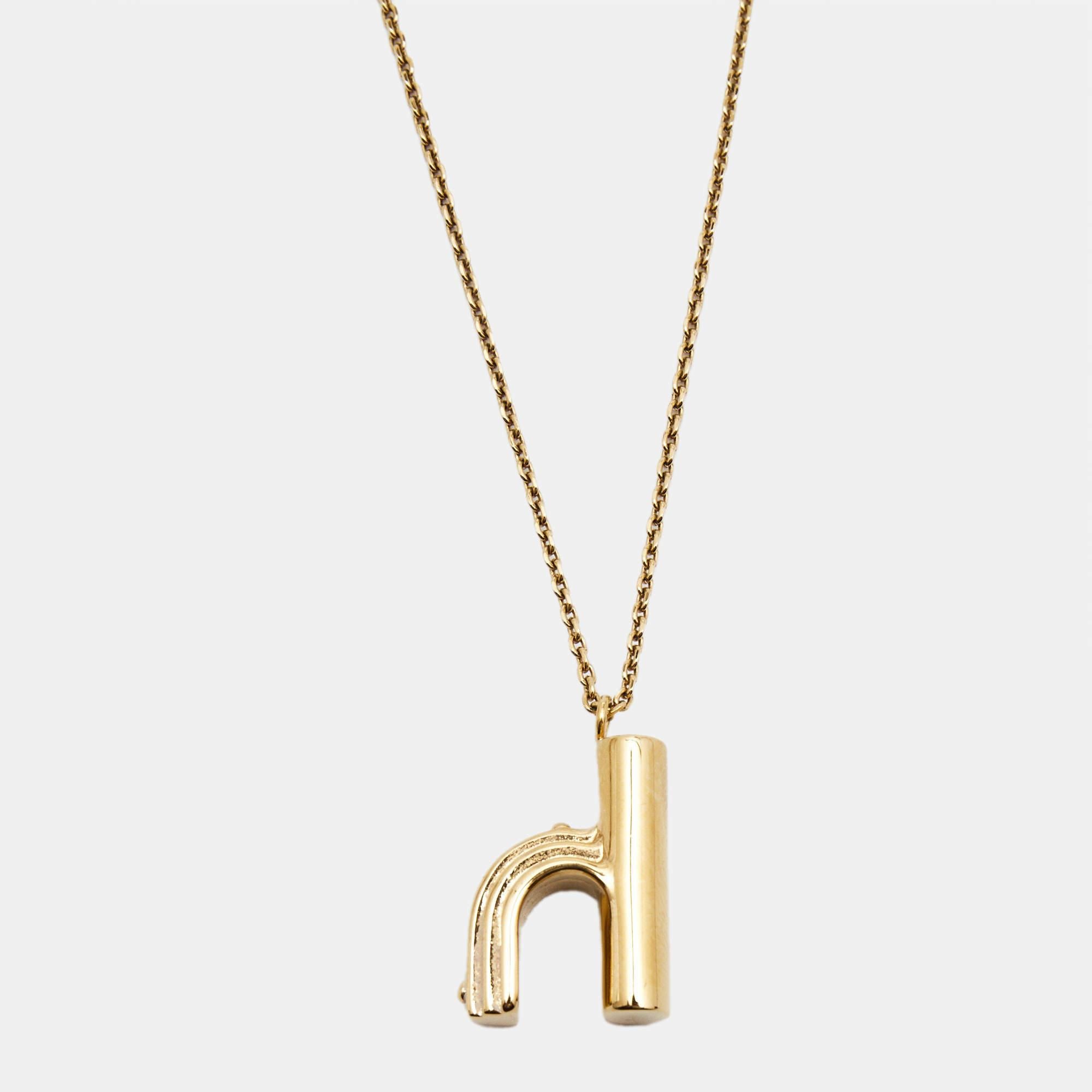 The Louis Vuitton LV & Me necklace is a luxurious fashion accessory. It features a gold-tone chain adorned with sparkling crystals and a pendant in the shape of the letter 