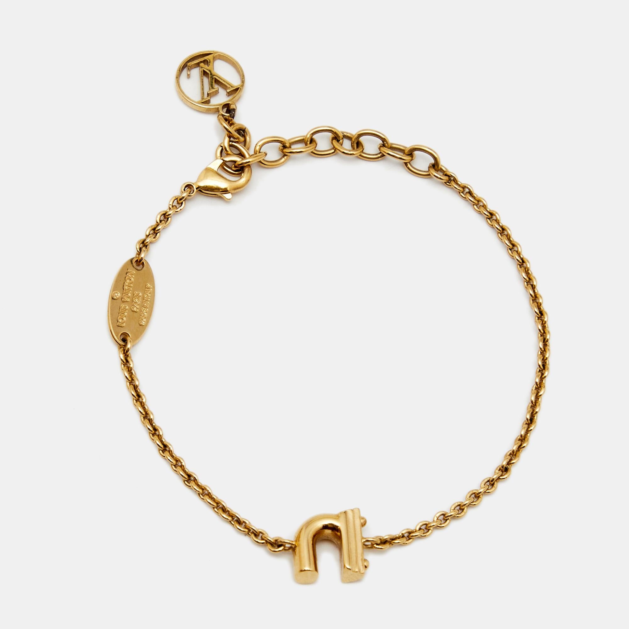 Louis Vuitton has yet again charmed all the LV lovers with this simple yet elegant bracelet. Designed in a gold-tone chain, this bracelet is centered with the letter 'N' and secured with a lobster clasp closure. This Italian-made piece also features